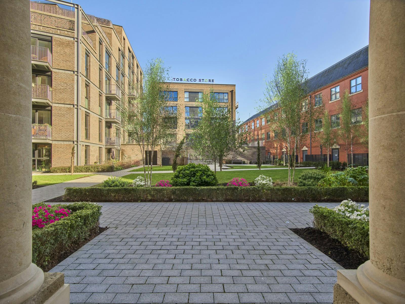 Caption: a courtyard with a walkway between two buildings