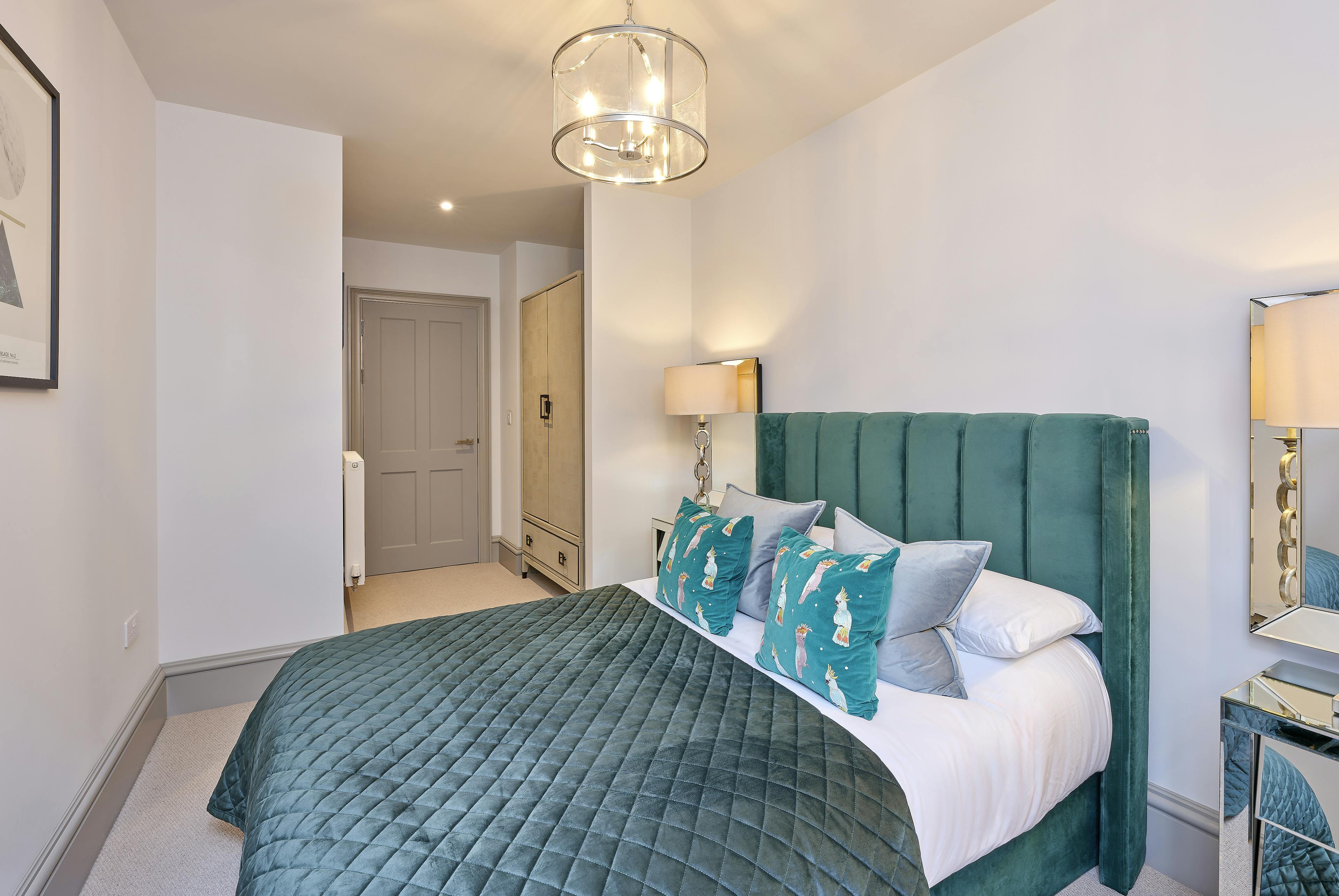 Caption: a bedroom with a green headboard and a white bed