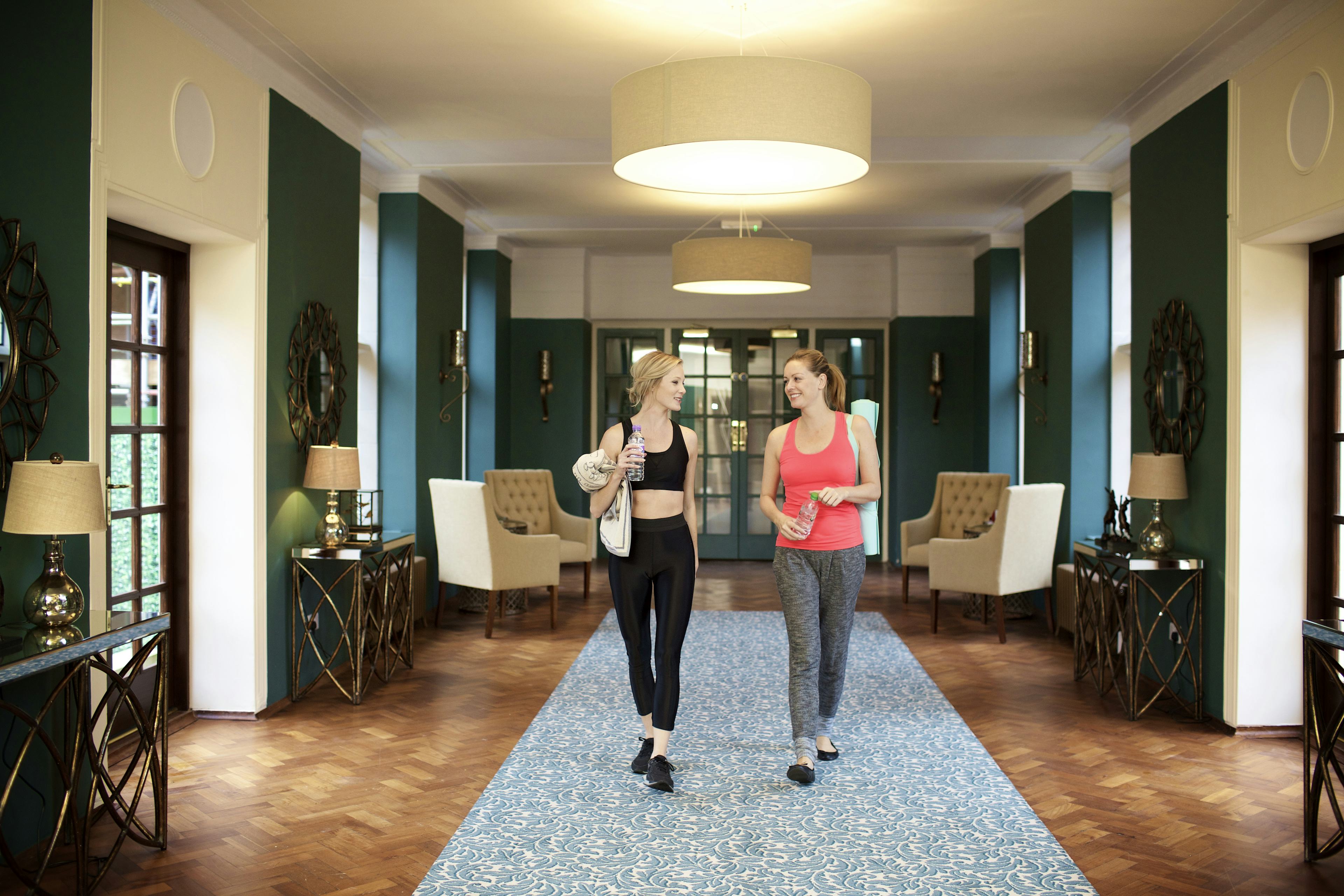 Caption: a couple of women walking down a hallway