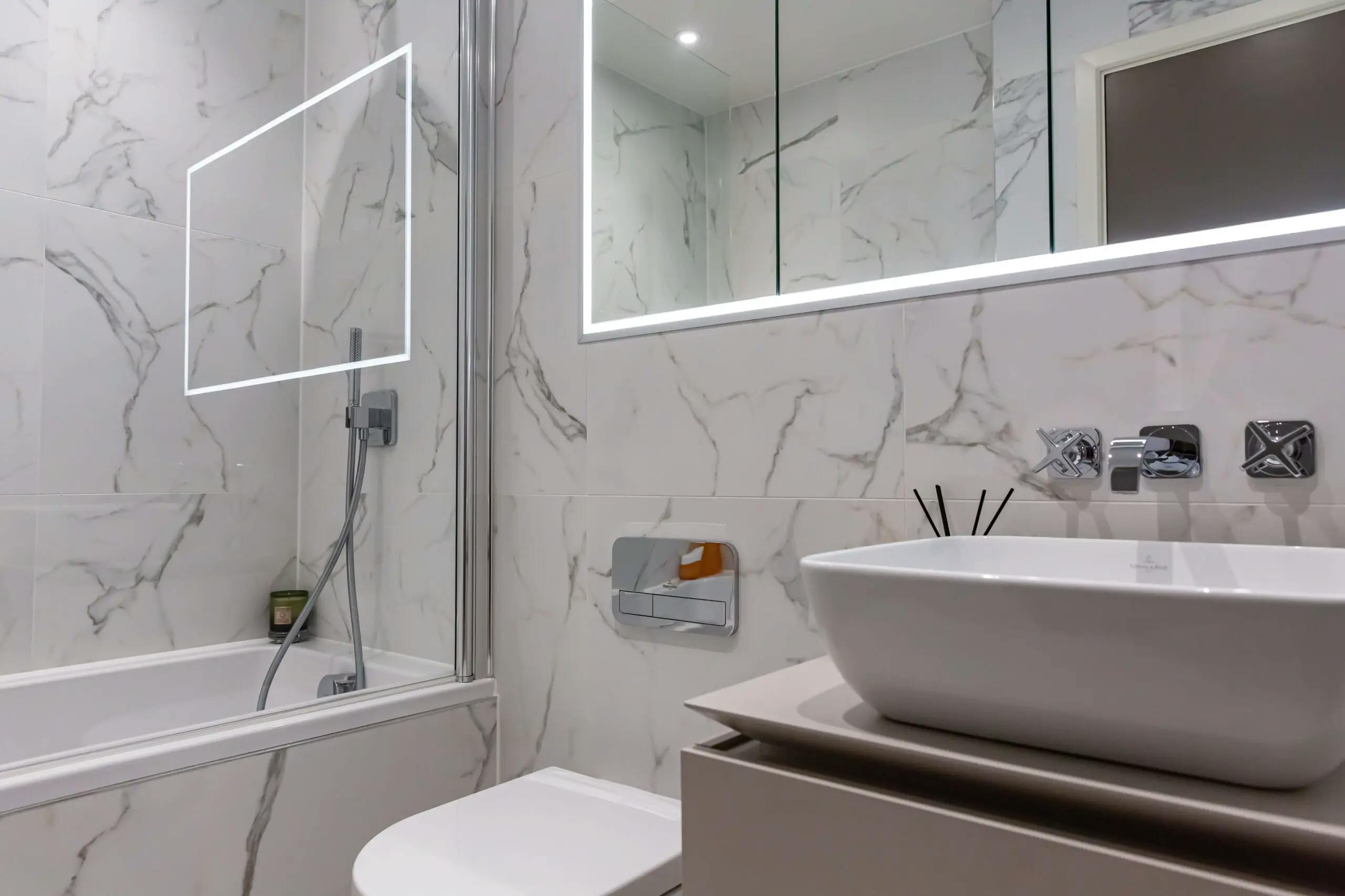 Caption: a bathroom with a sink, mirror, toilet and bathtub