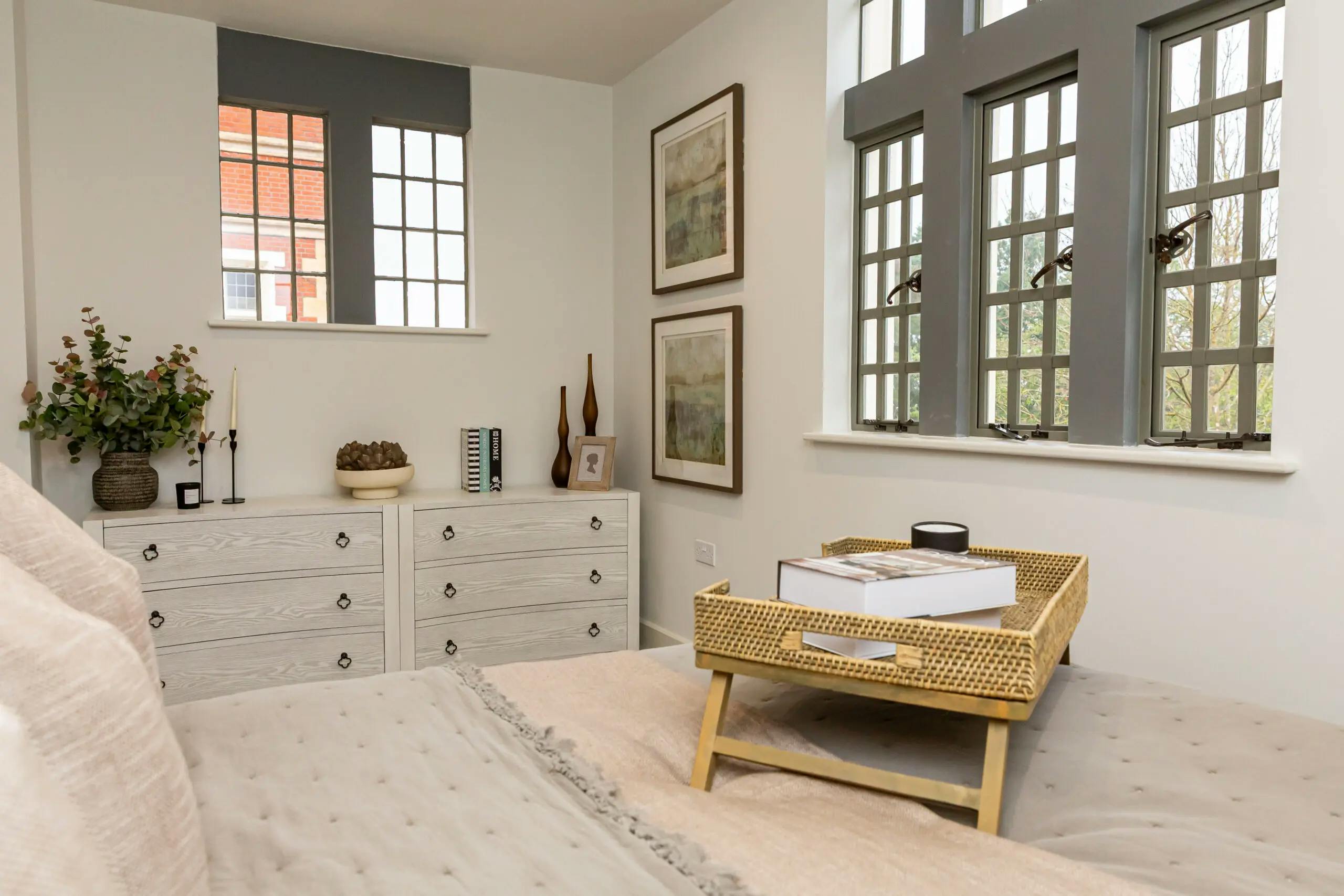 Caption: a bedroom with a wicker tray on the bed