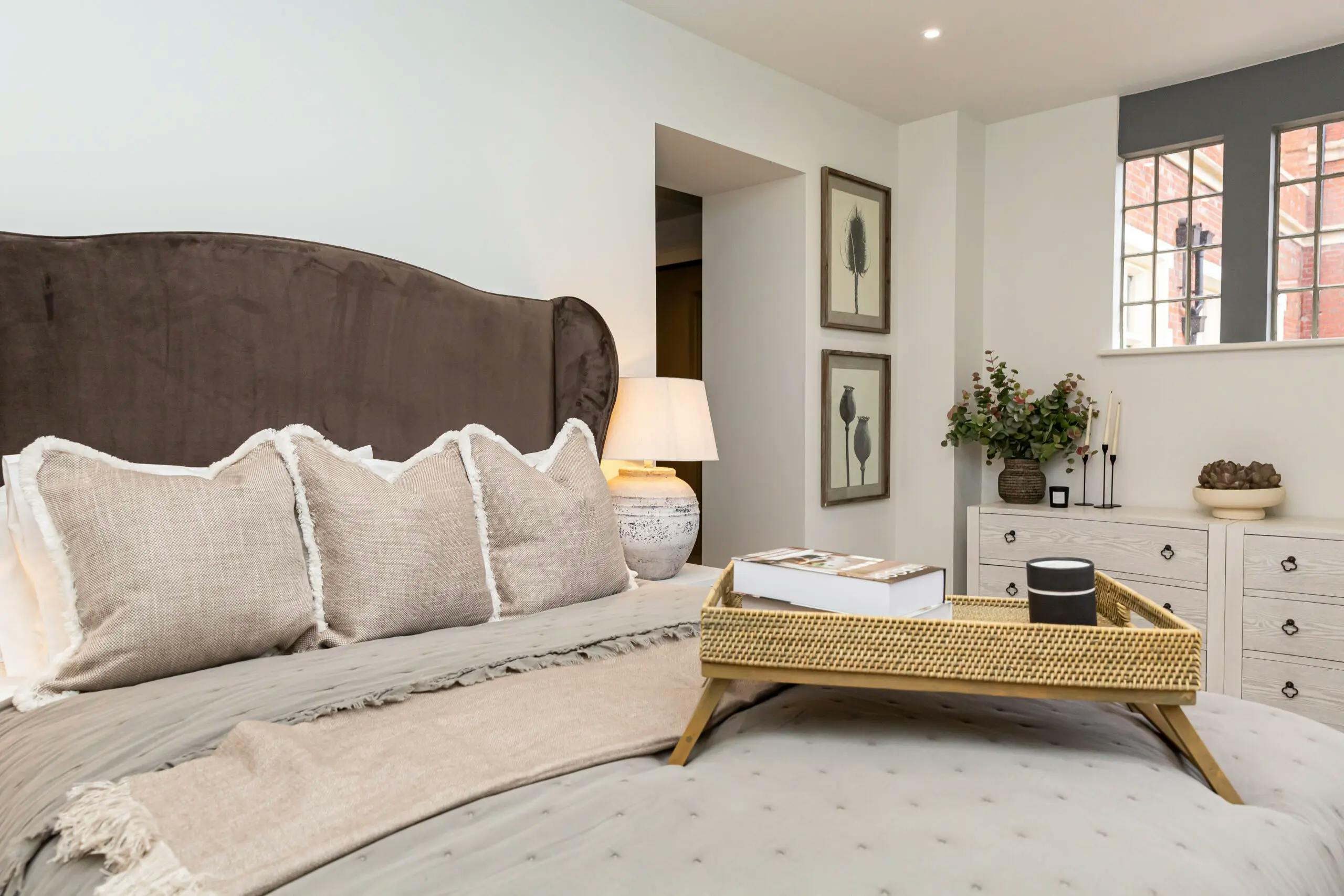 Caption: a bed with a tray of books on top of it