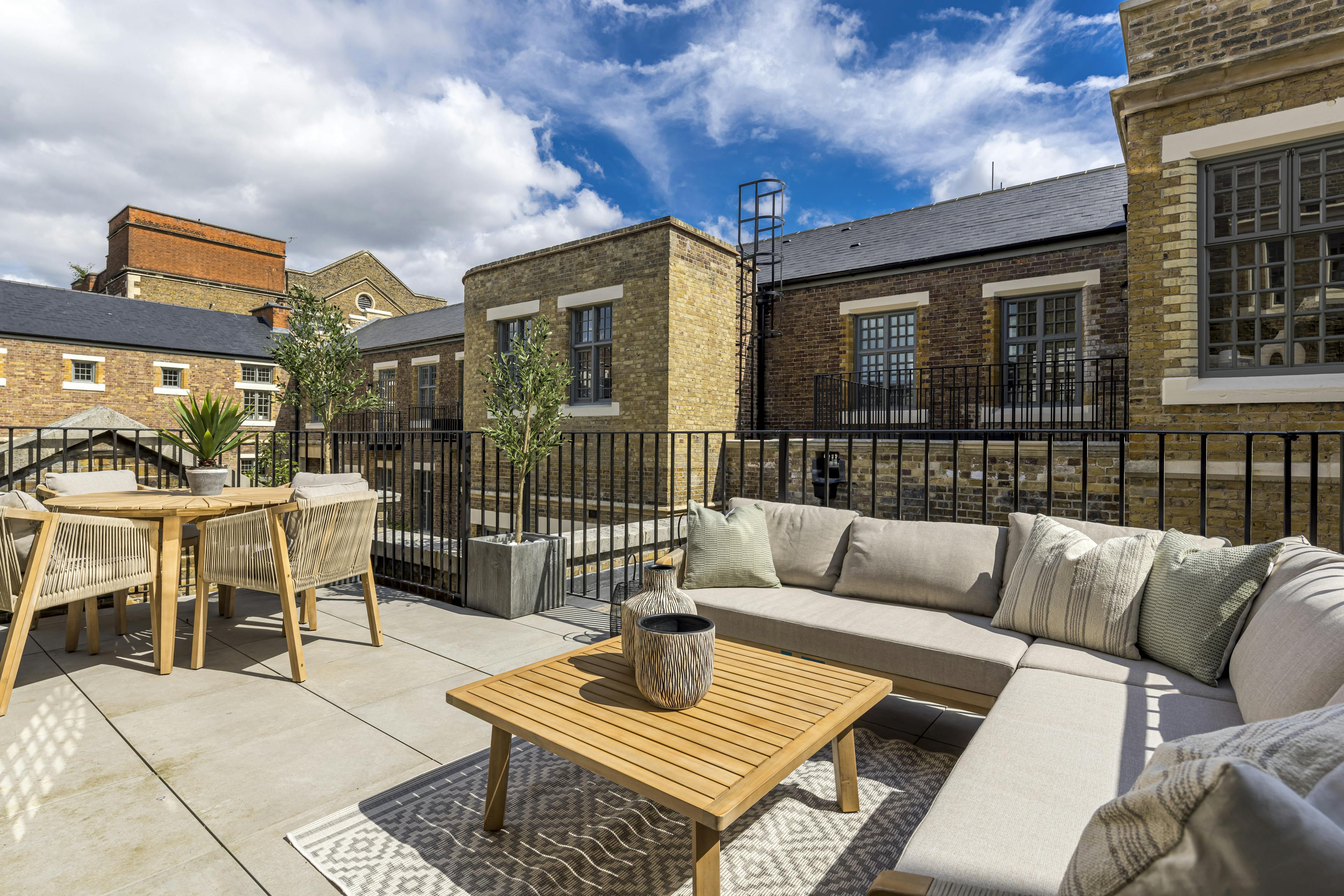 Caption: a patio with a couch, table and chairs
