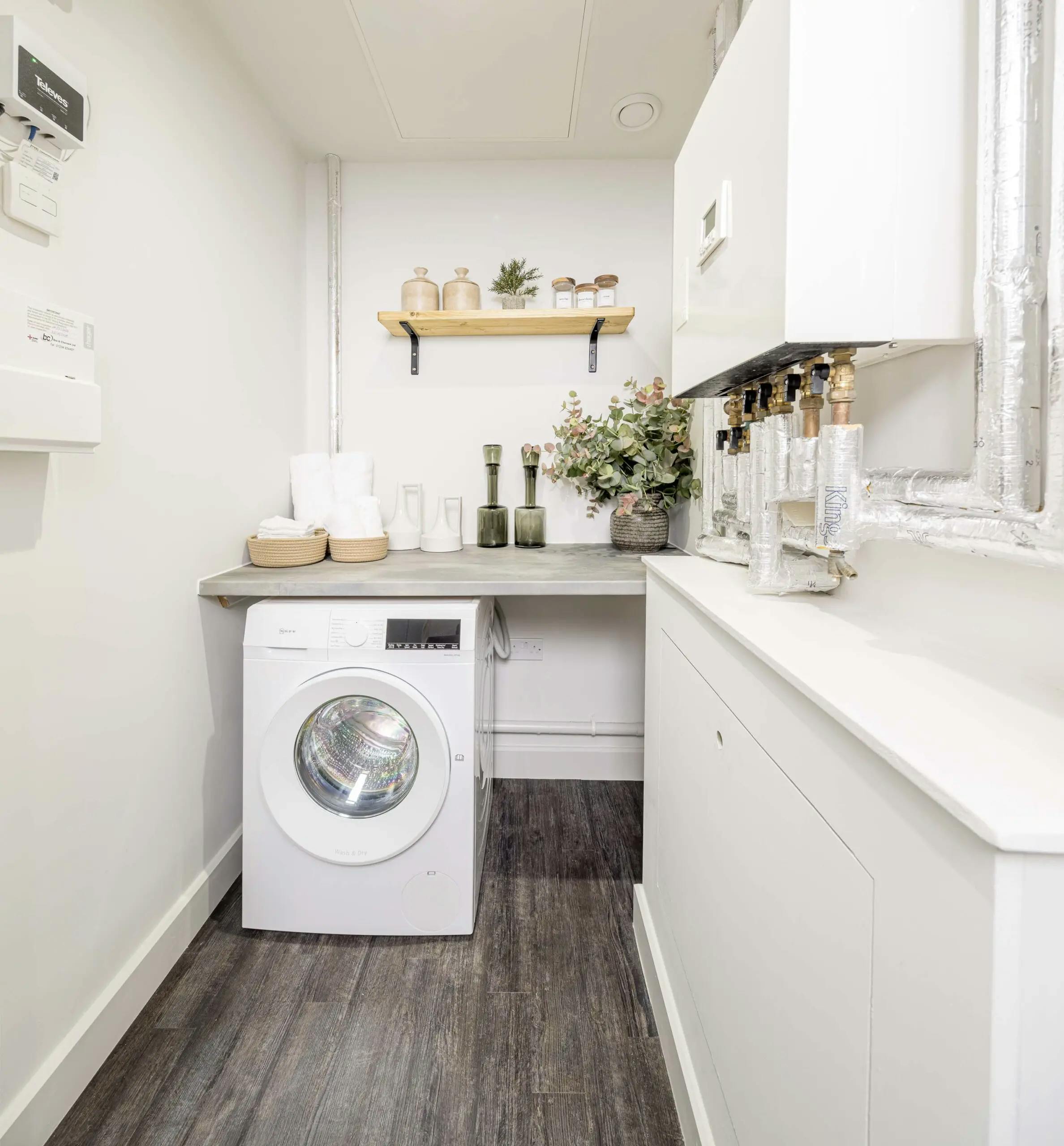 Caption: a laundry room with a washer and dryer