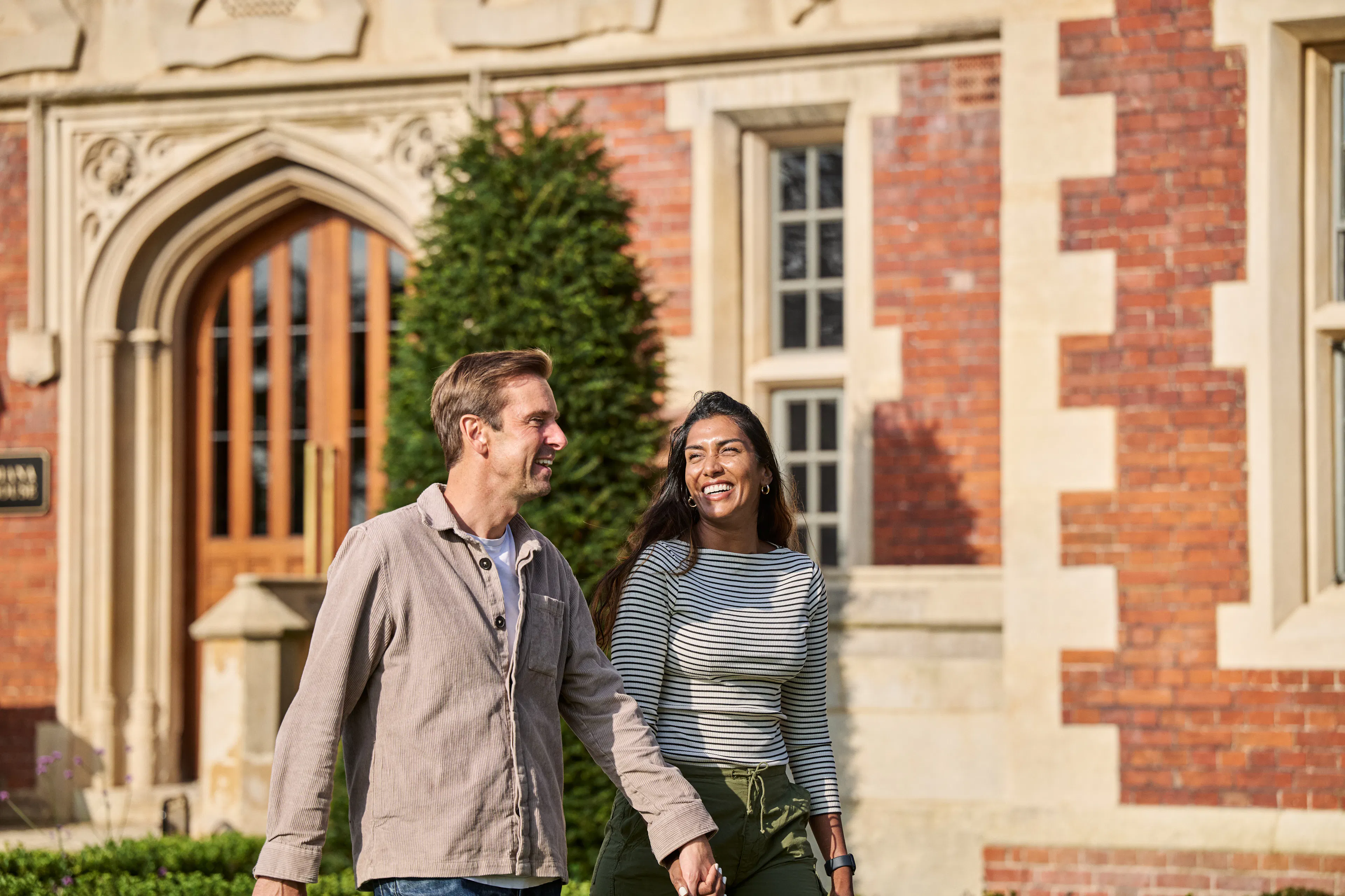 Caption: a man and a woman walking in front of a building