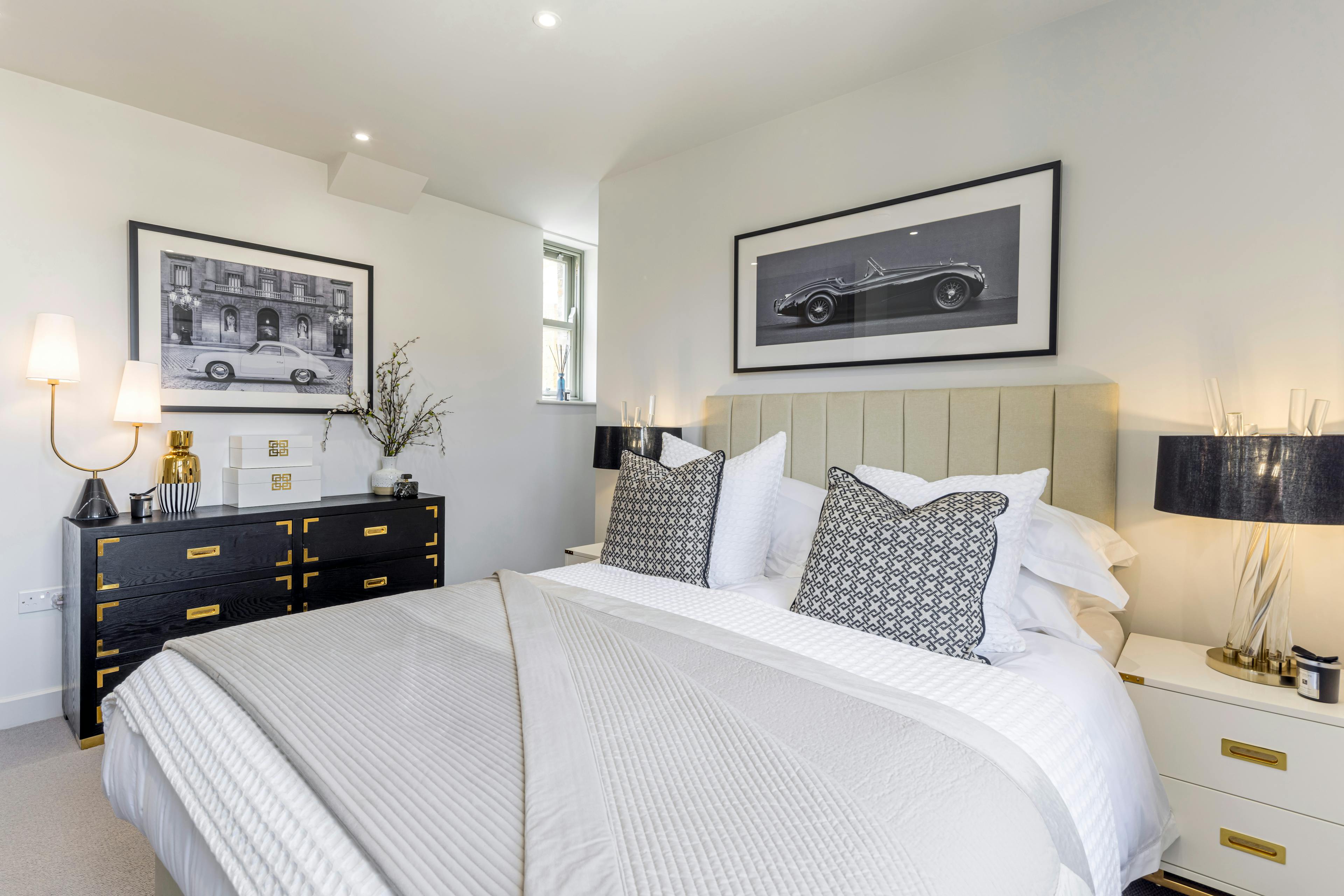 Caption: a bedroom with a bed, dresser, and pictures on the wall