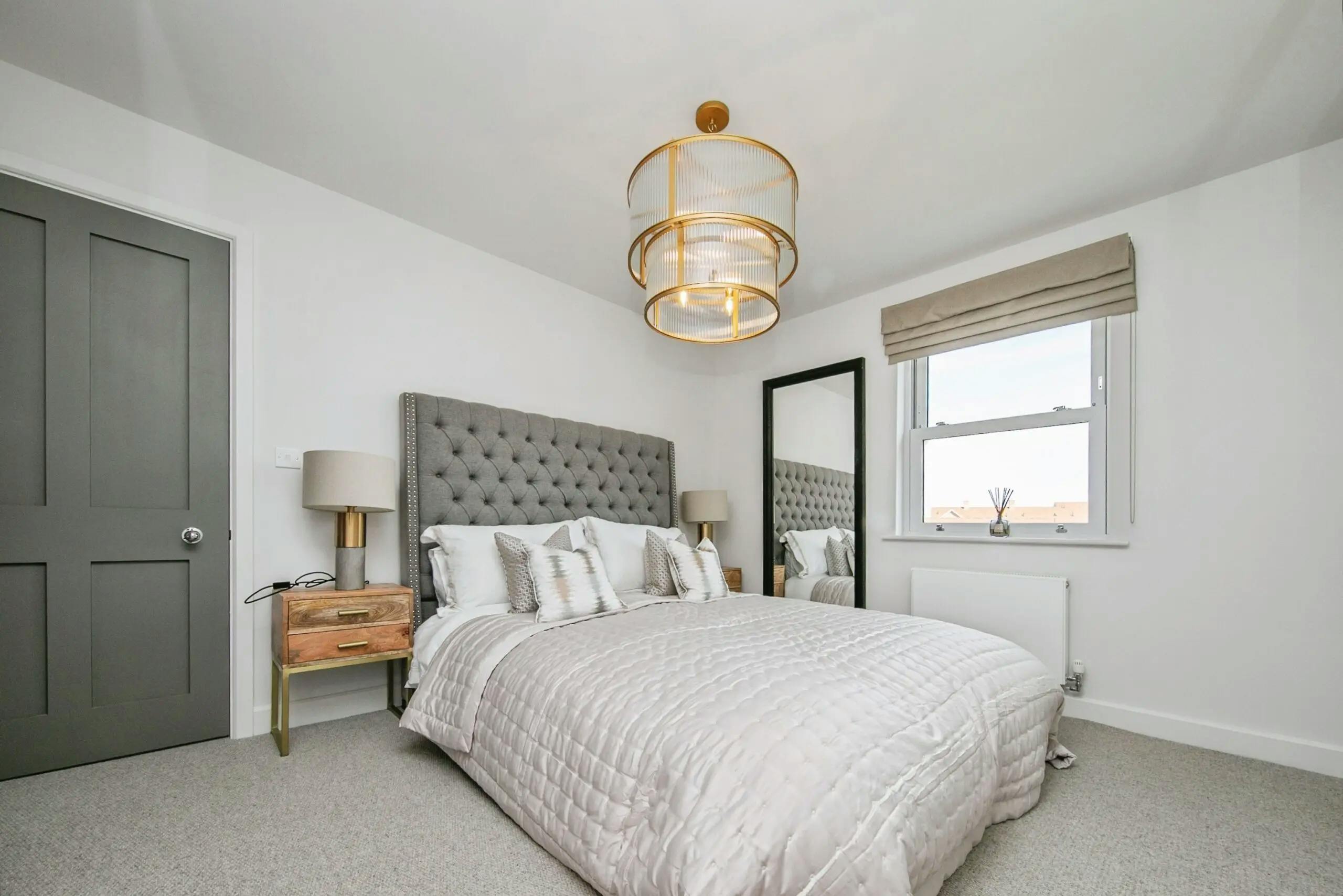 Caption: a bedroom with a large bed and a large window