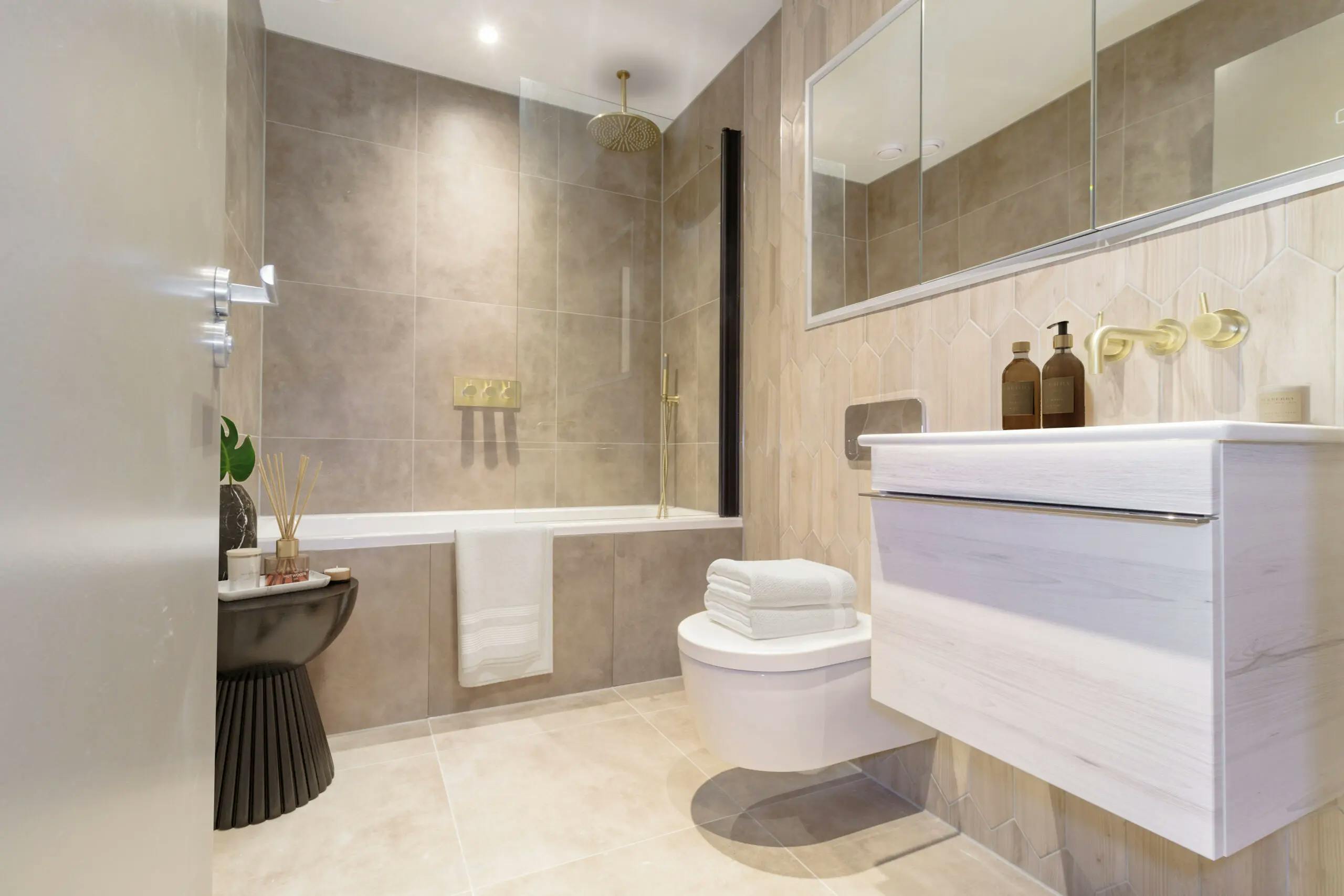 Caption: a bathroom with a toilet, sink, mirror and bathtub