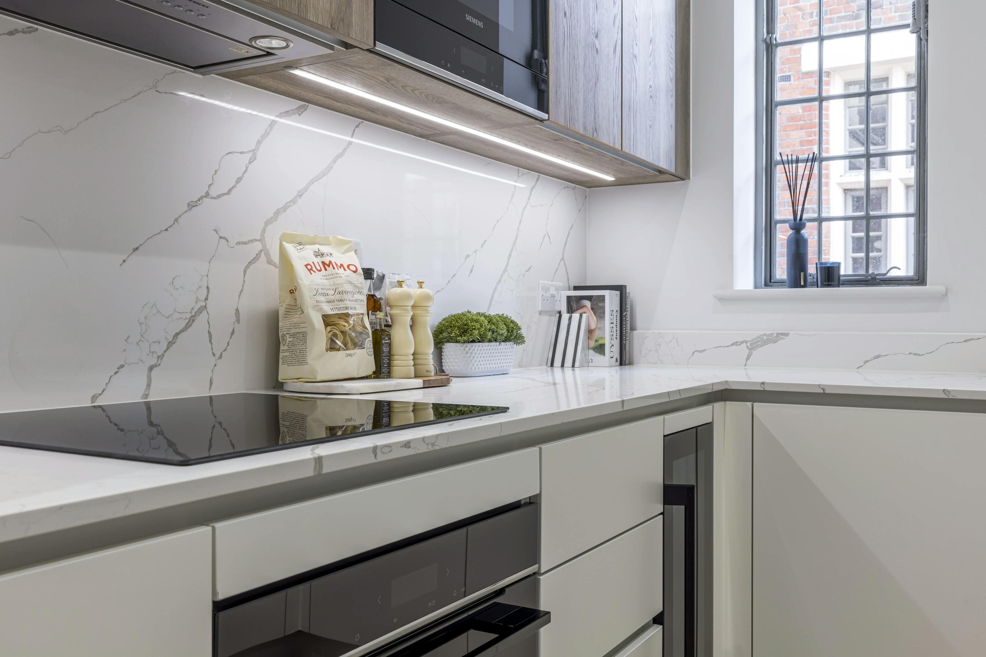 Caption: a kitchen with marble counter tops and white cabinets