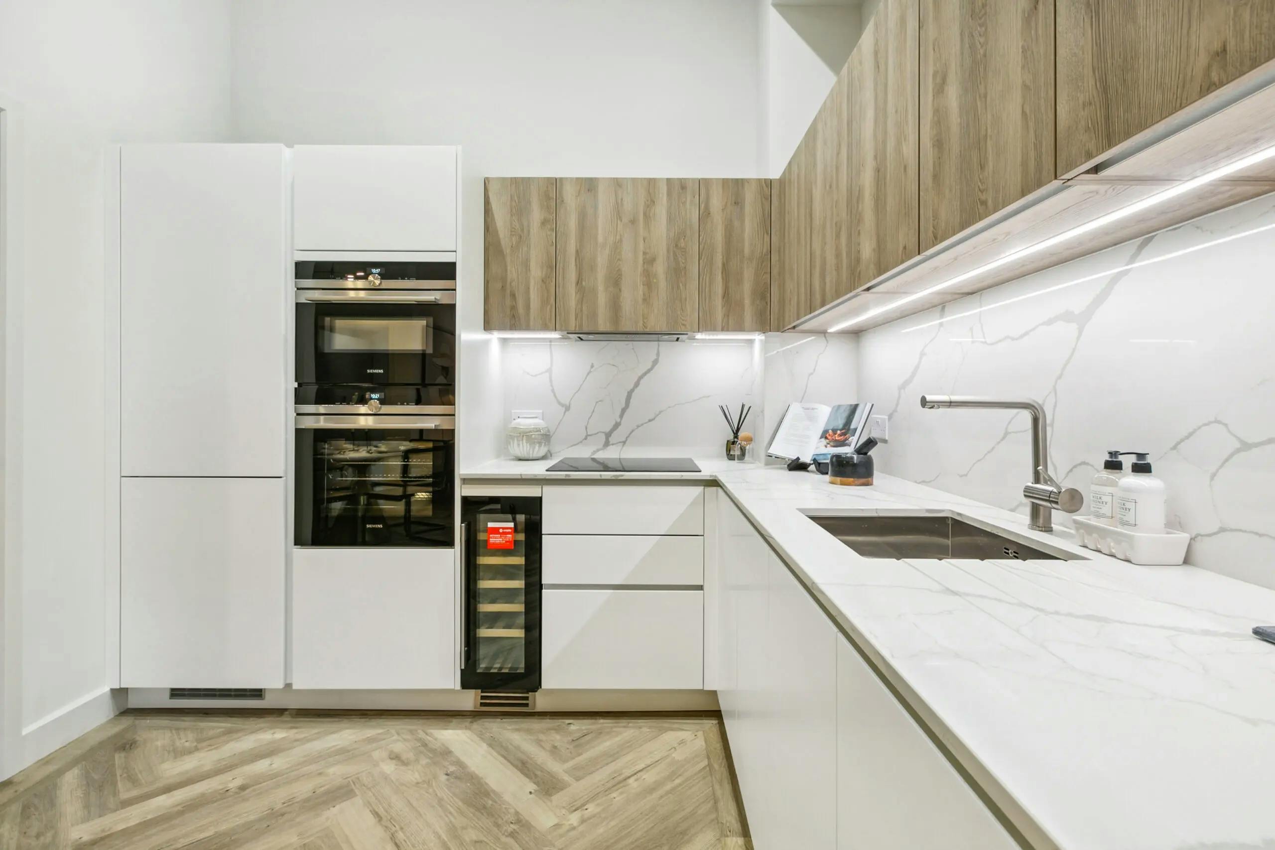 Caption: a kitchen with a marble counter top and white cabinets