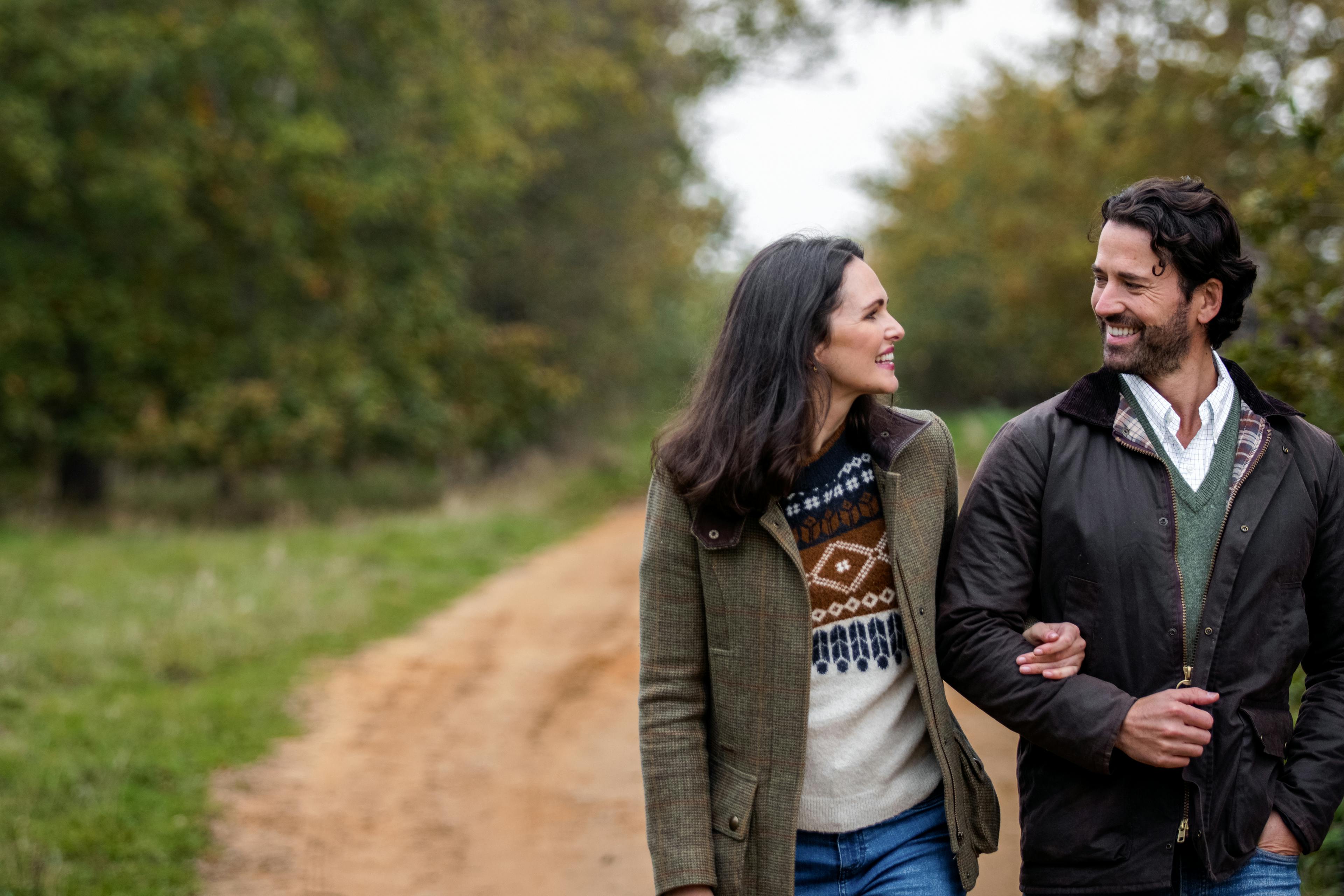 Caption: a man and a woman walking down a dirt road