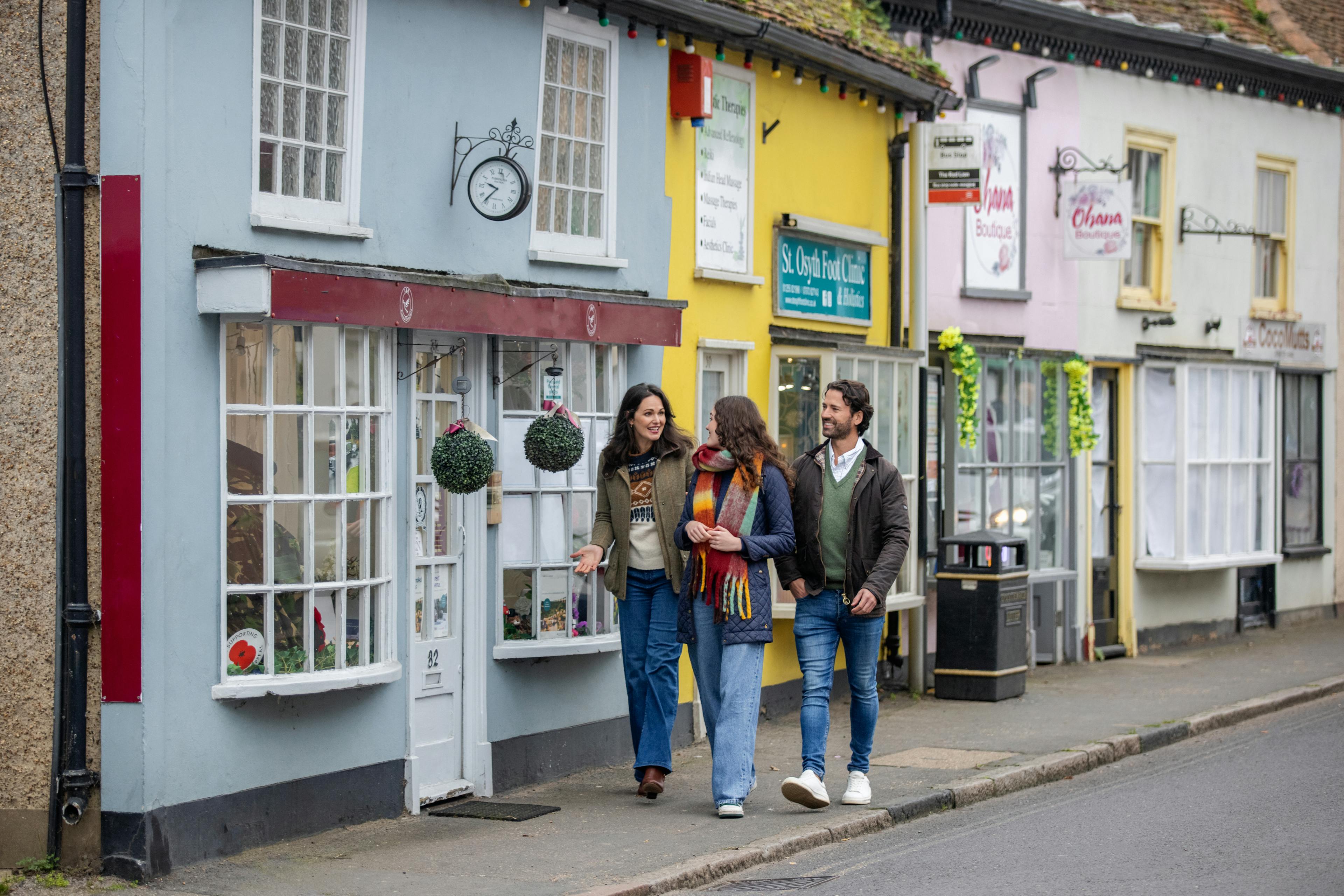 Caption: a group of people walking down a street next to a building