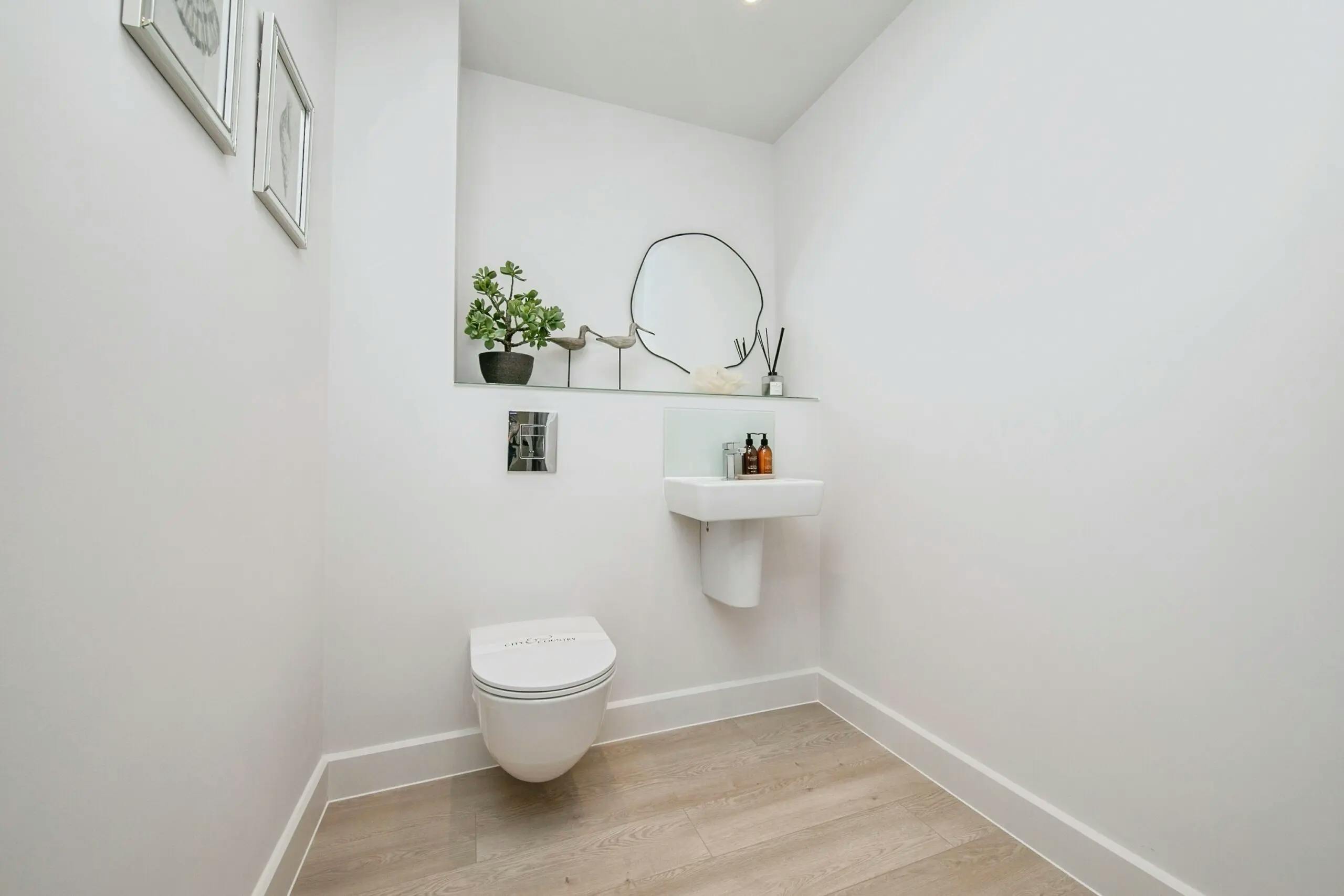 Caption: a bathroom with a toilet, sink and mirror