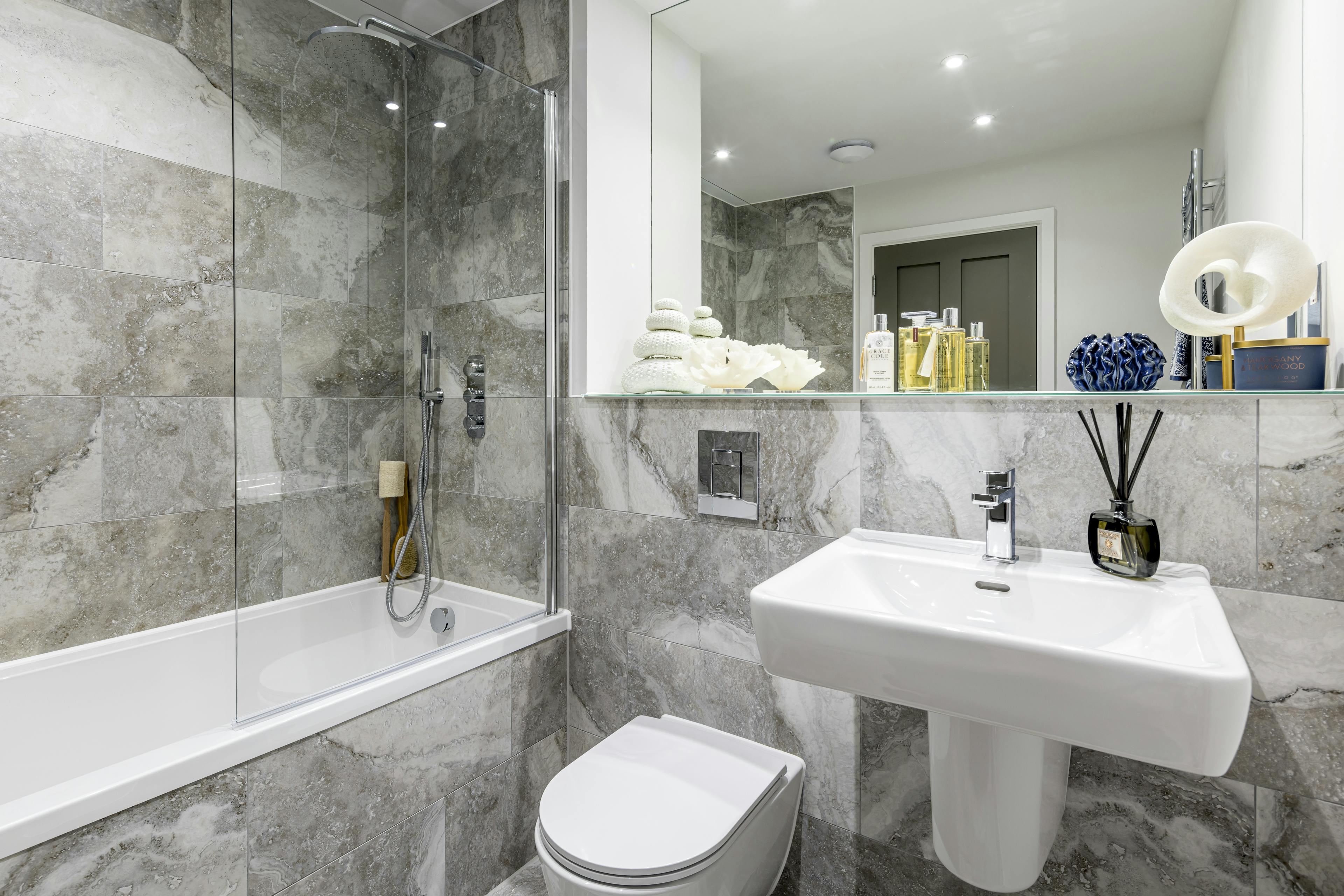 Caption: a white toilet sitting next to a bath tub in a bathroom