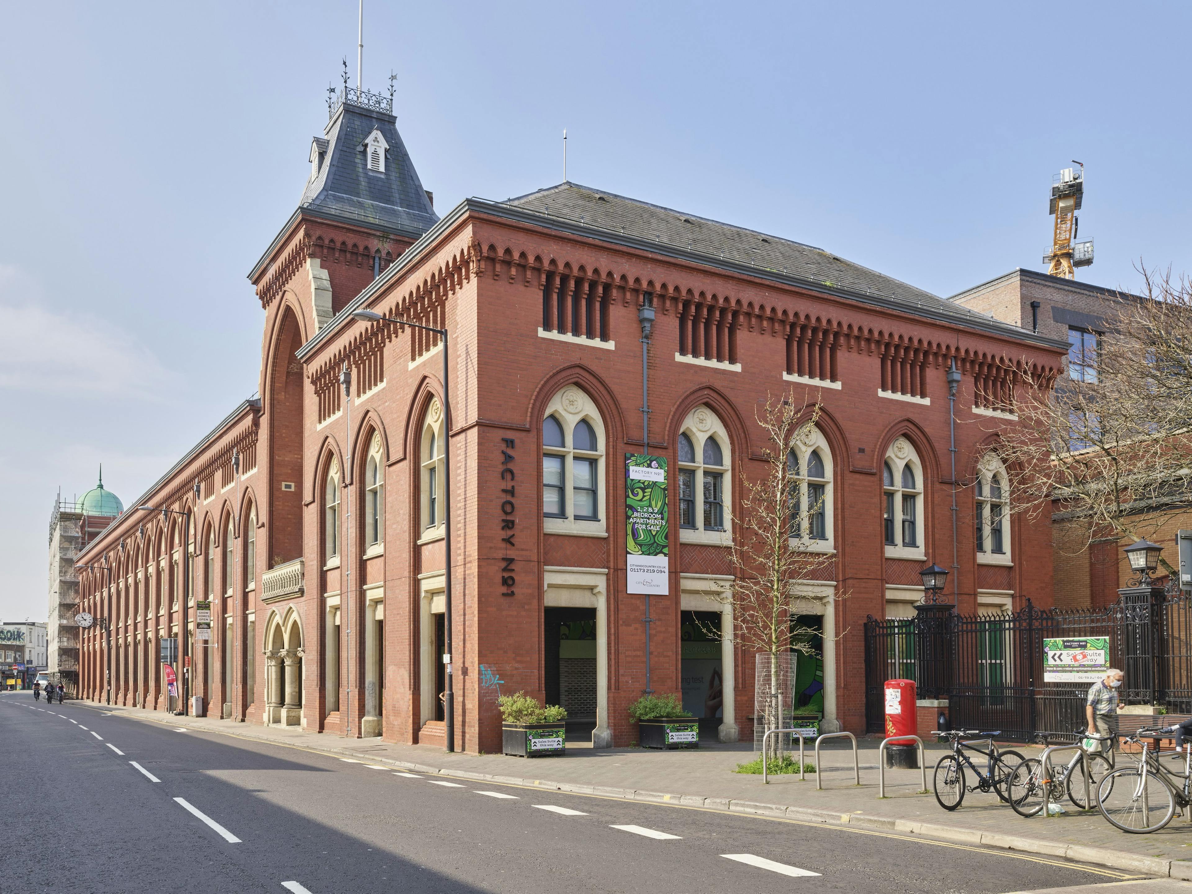 The front of a large brick building on a main road