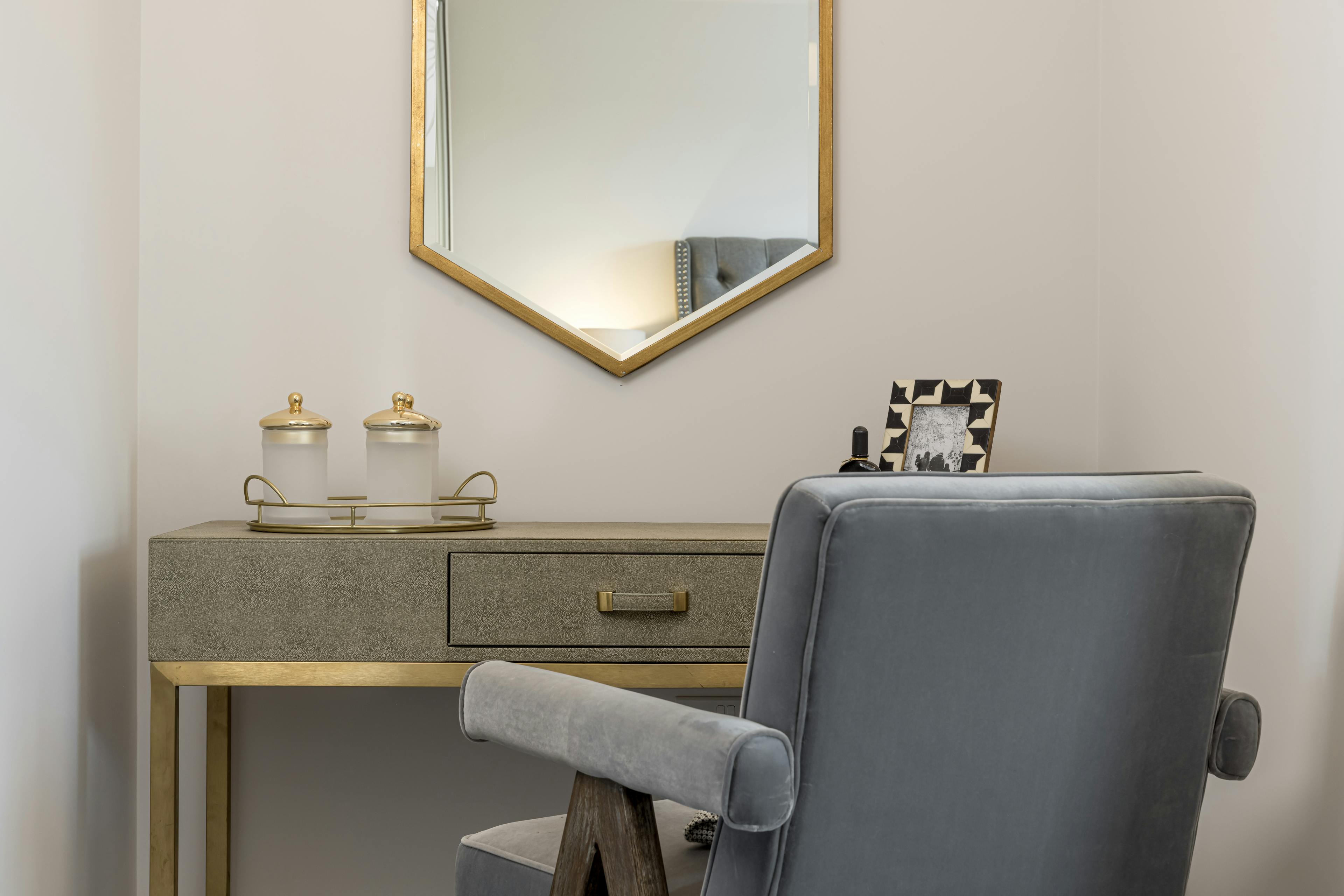 Caption: a desk with a chair and a mirror