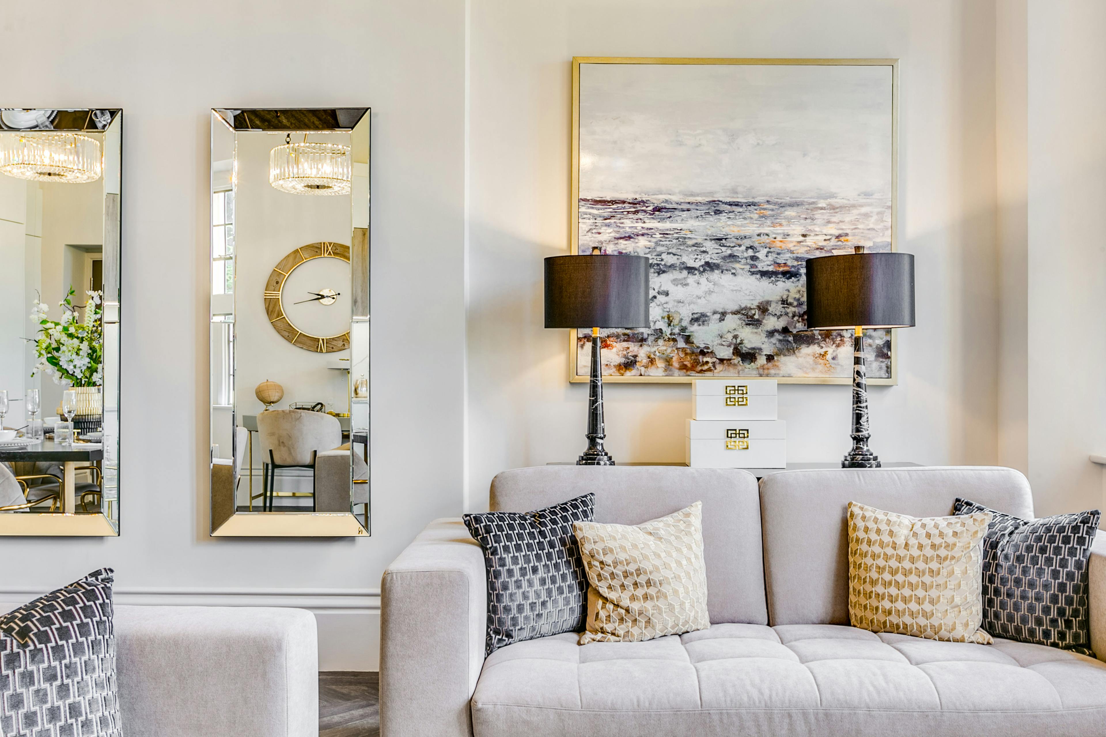 Caption: a living room filled with furniture and a large mirror