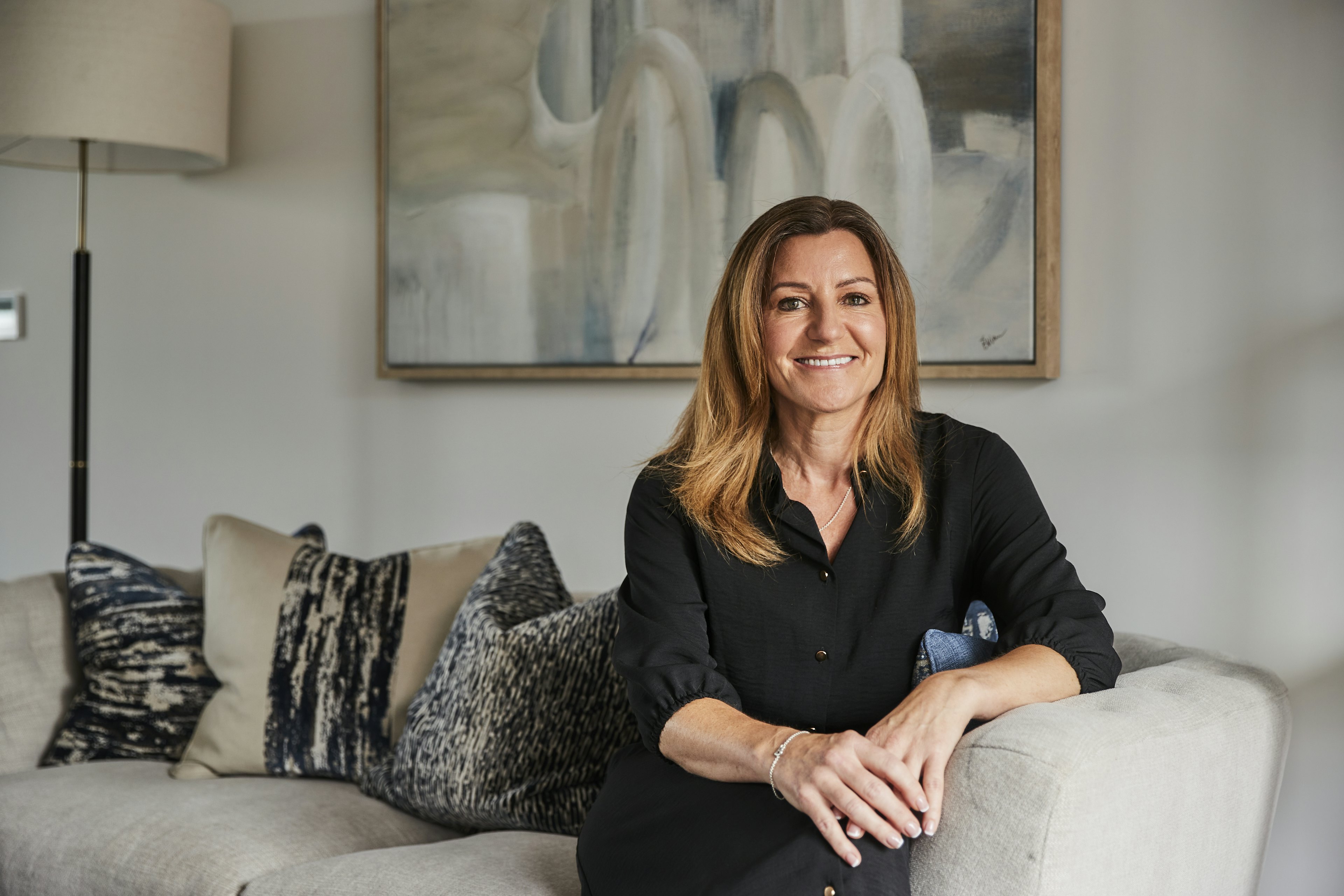 Caption: a woman sitting on a couch in a living room