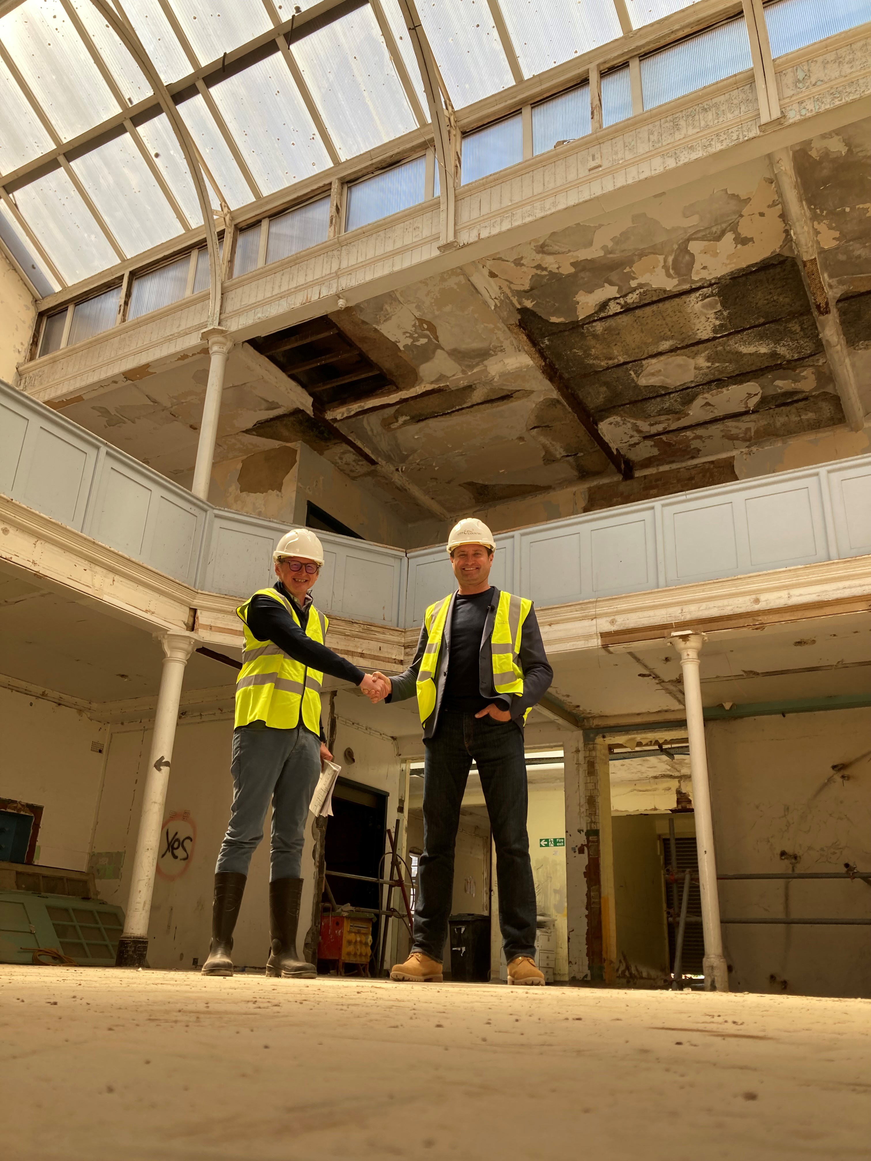 Caption: two construction workers shaking hands in a building