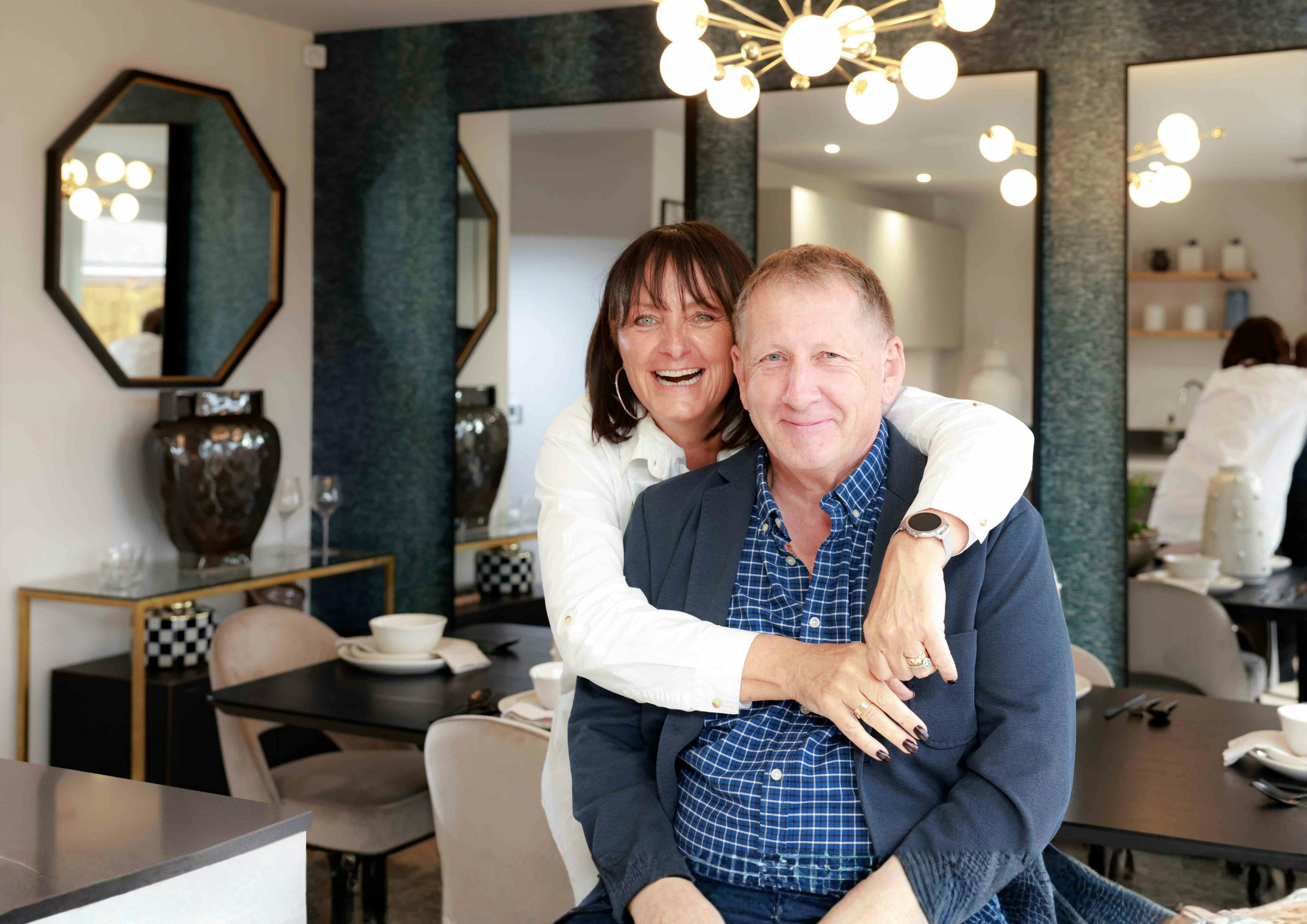 Caption: a man and a woman are hugging in a restaurant