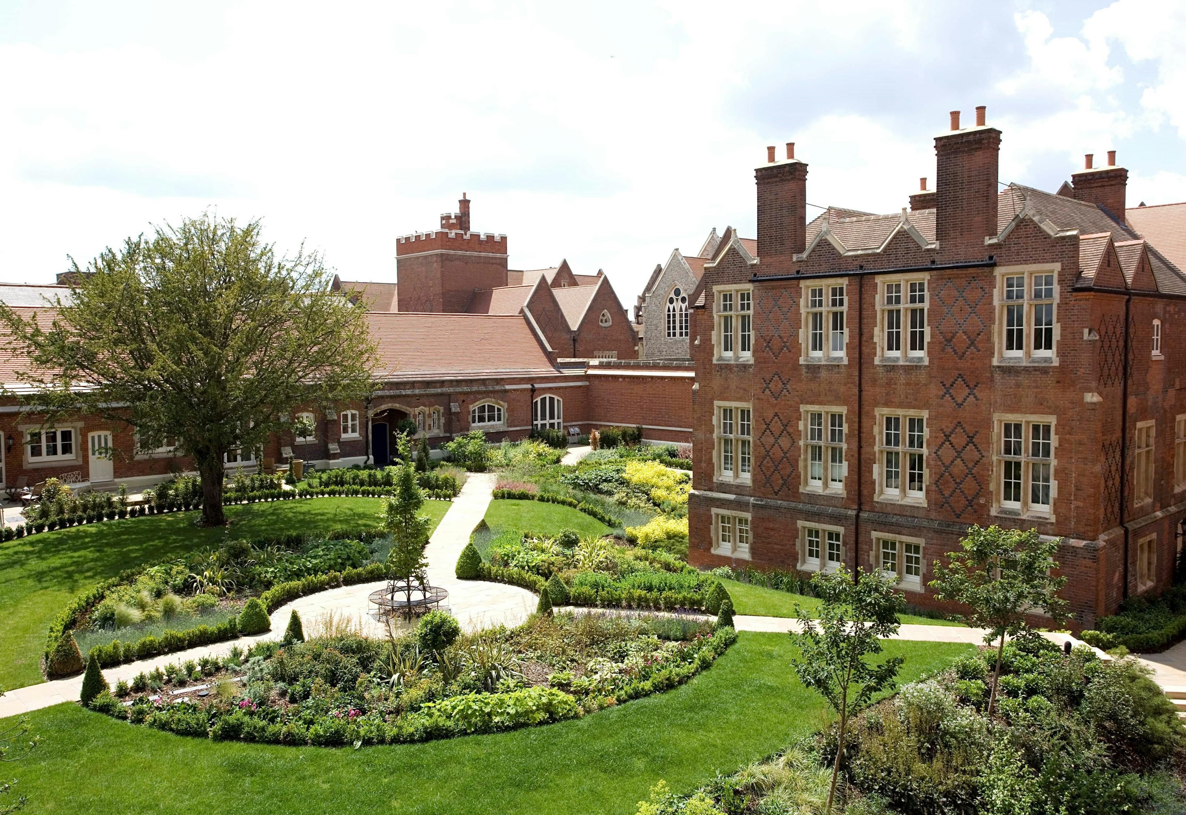 Caption: a large building with a garden in front of it