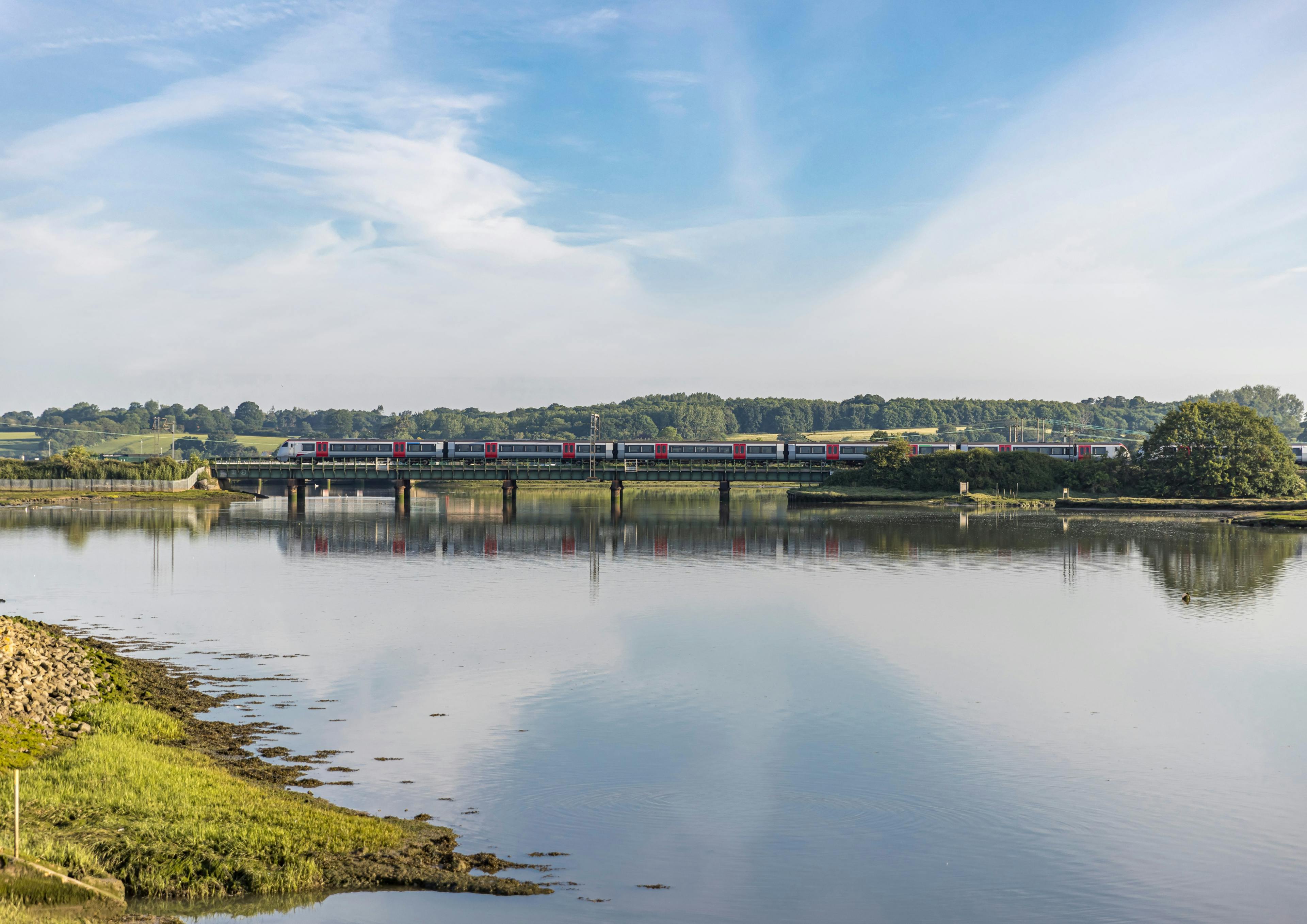 Caption: a train traveling over a bridge over a river