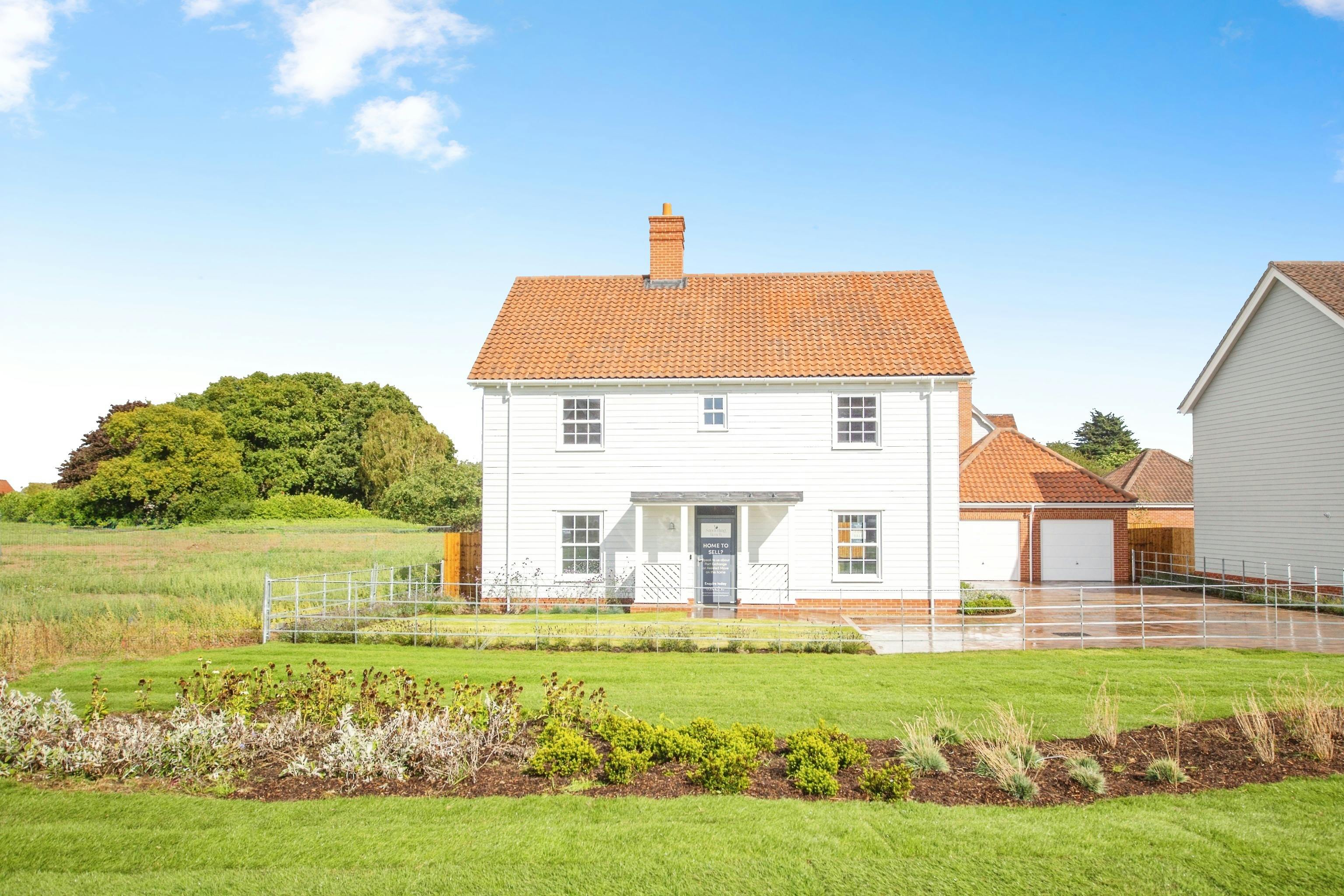 Caption: a white house sitting in a lush green field