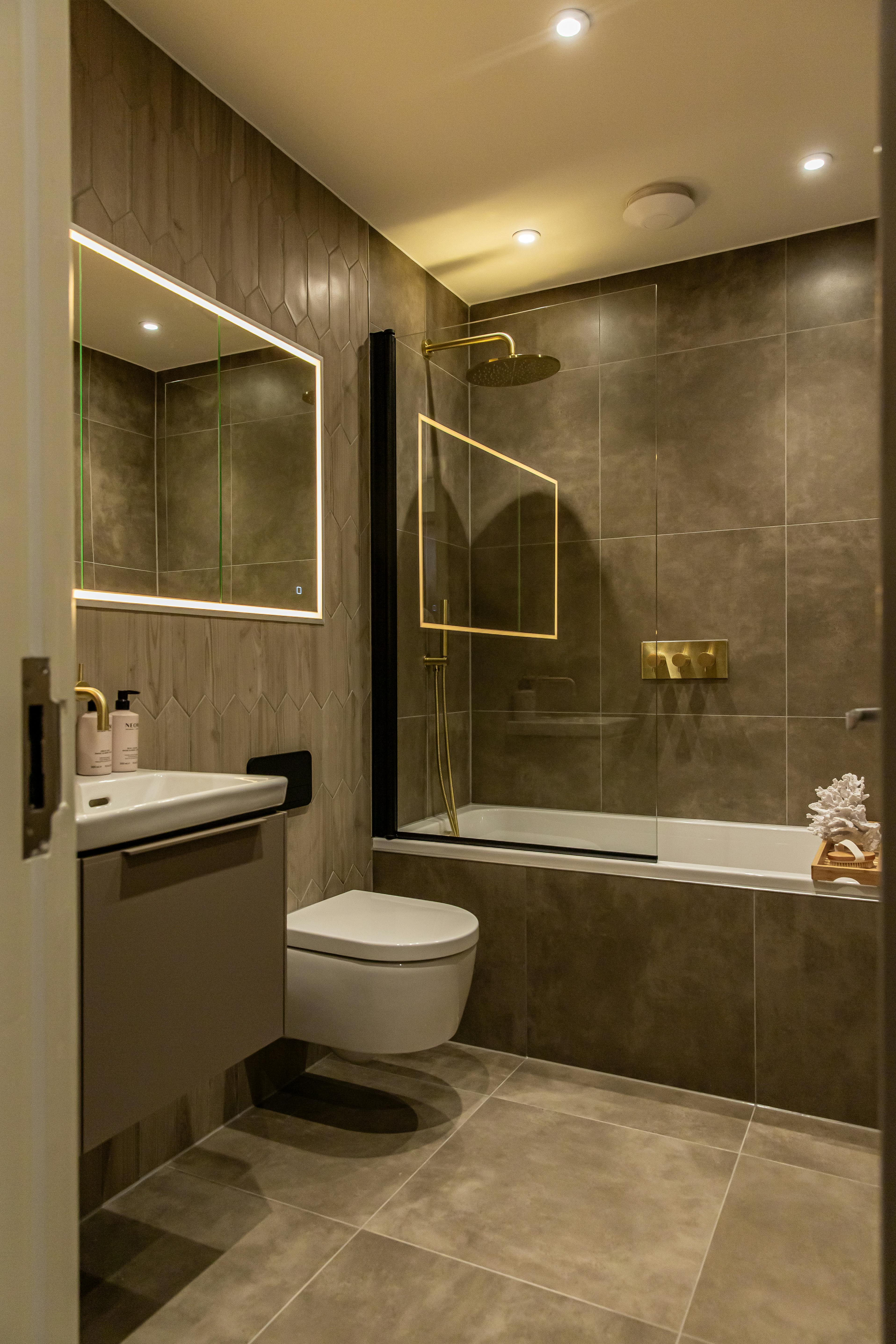 Caption: a bathroom with a toilet, sink, mirror and bathtub