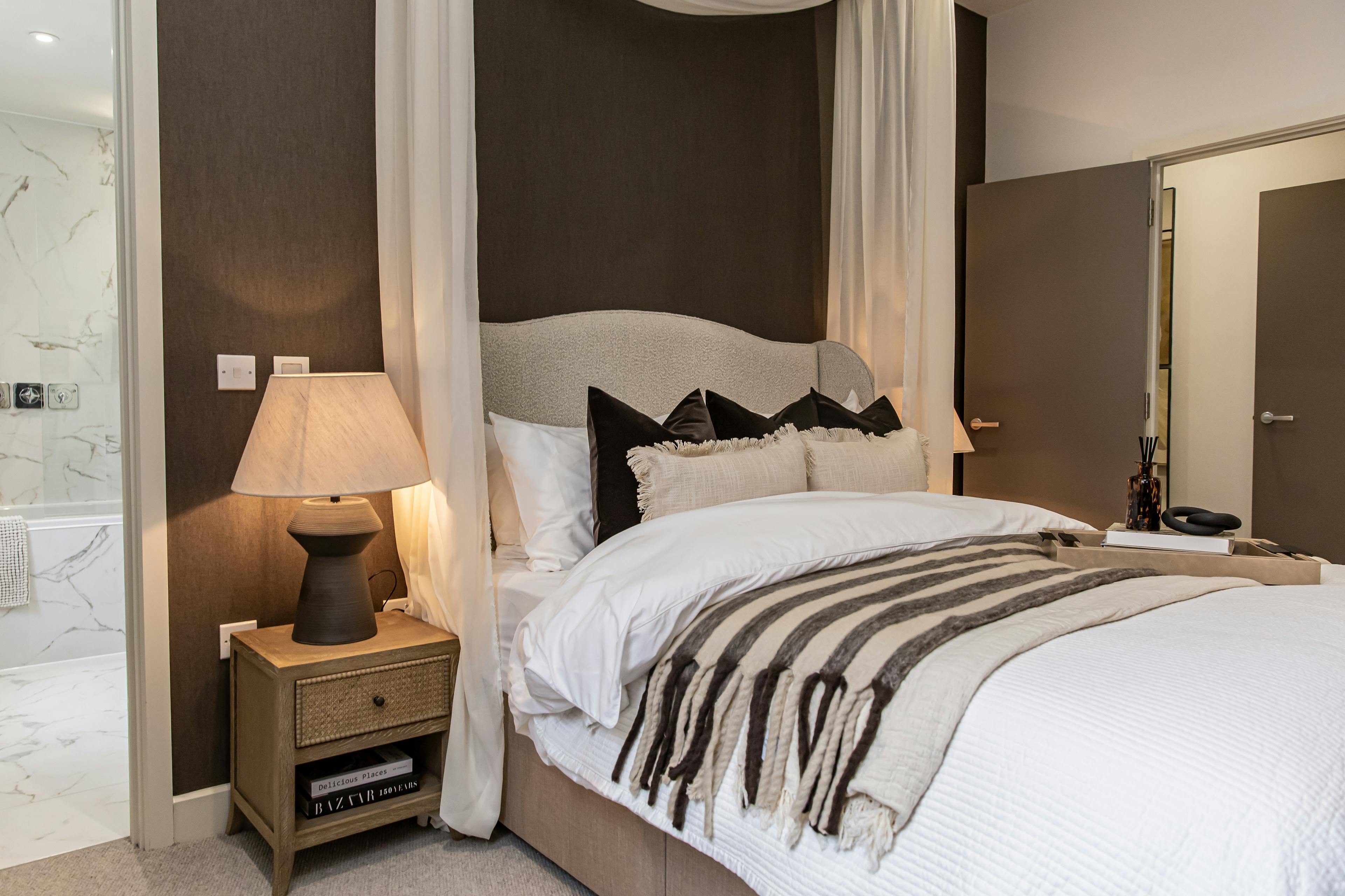 Caption: a bedroom with a bed, nightstand, and mirror