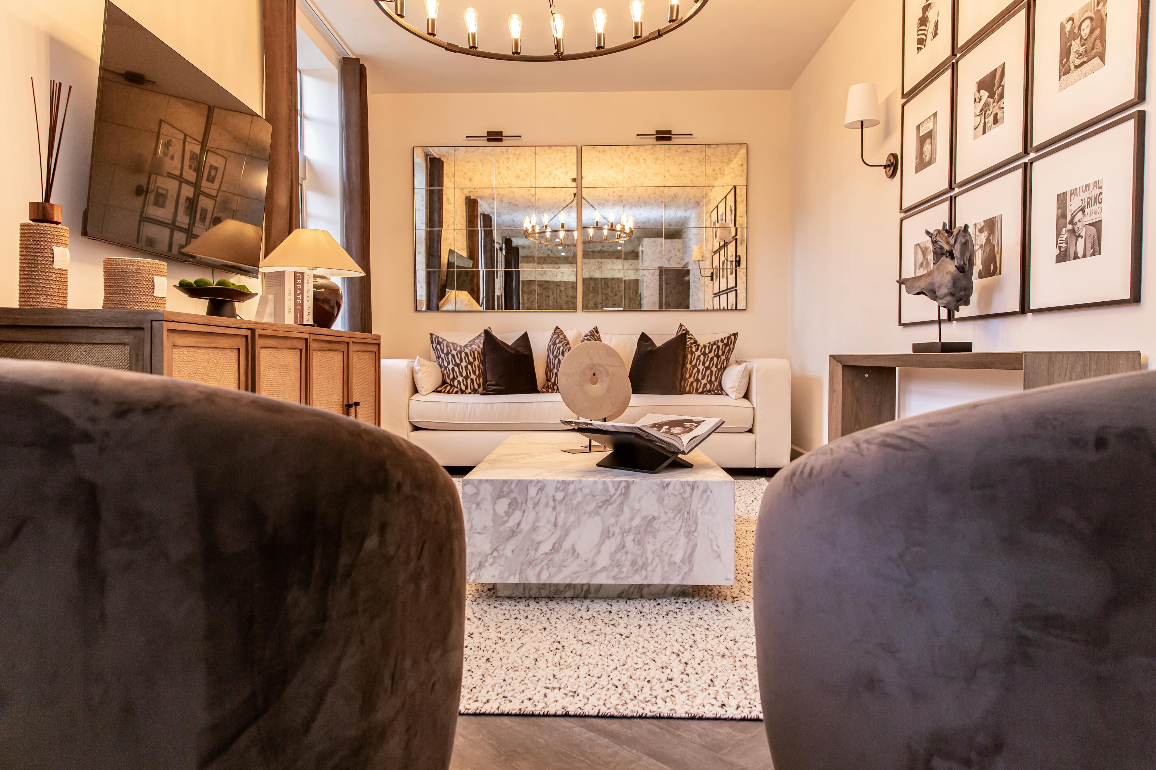 Caption: a living room filled with furniture and a large mirror