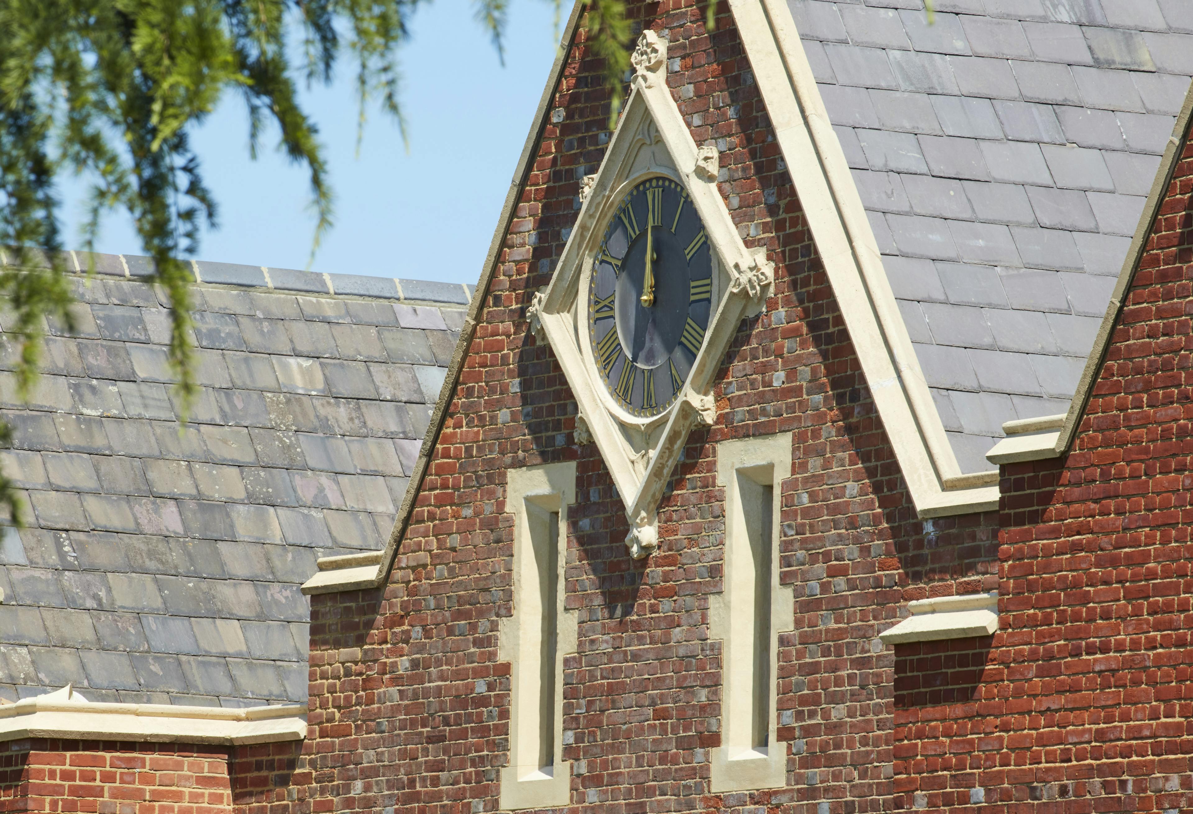 Caption: a clock on the side of a brick building
