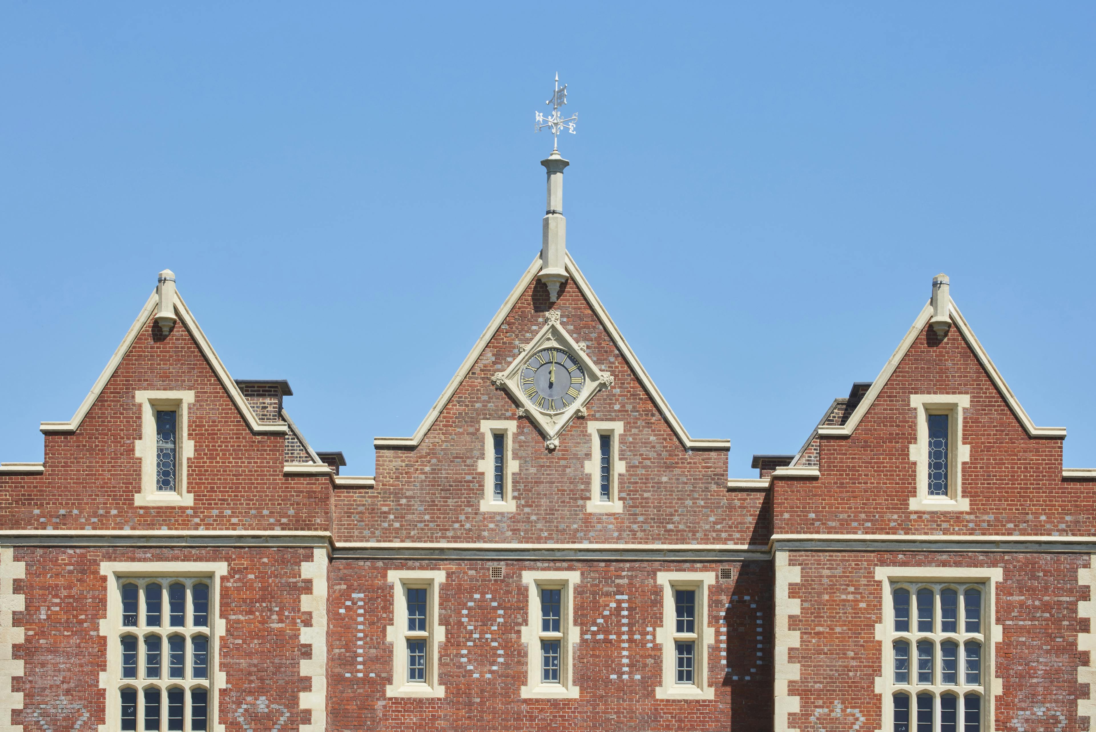 Caption: a large brick building with a clock on the top of it