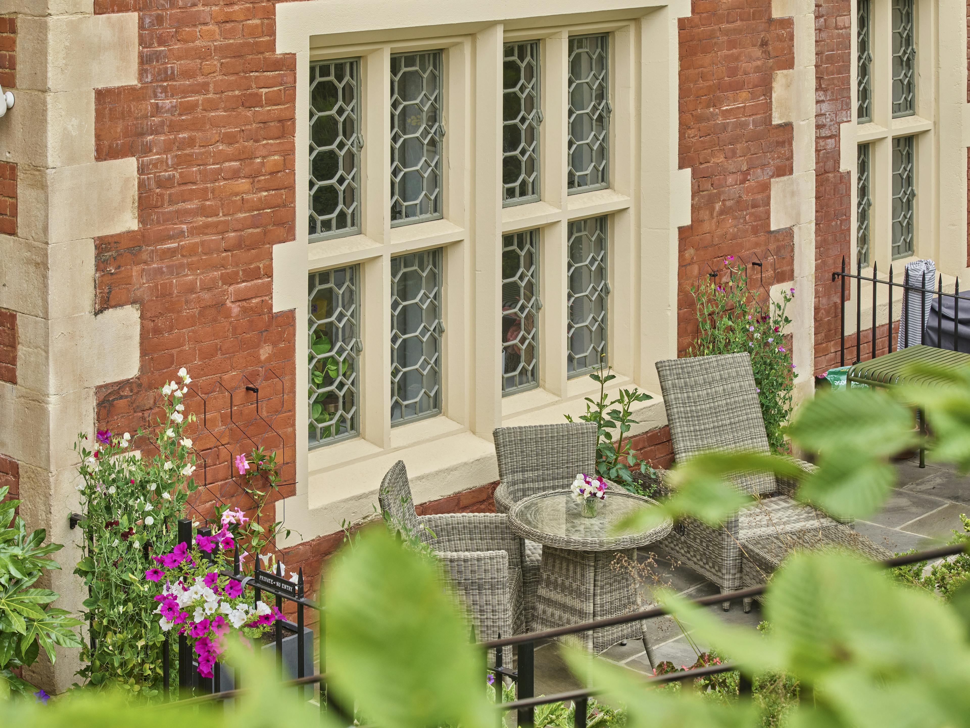 Caption: a patio with a table and chairs next to a brick building