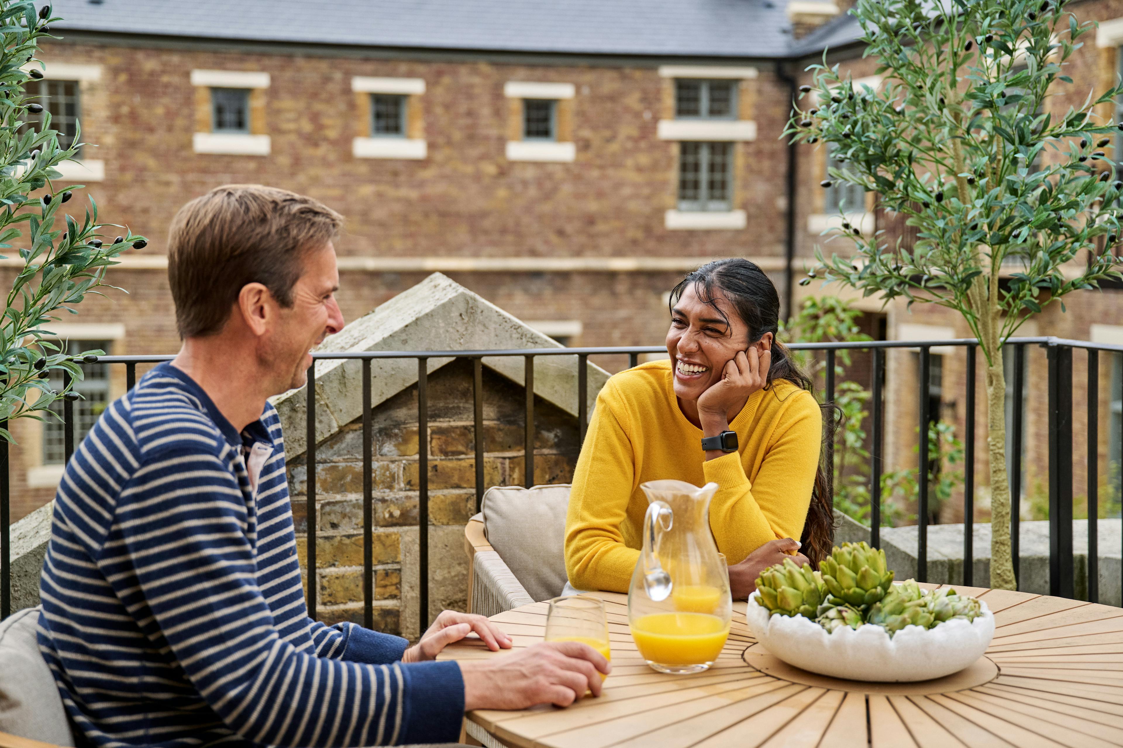 Caption: a man and a woman sitting at a table talking