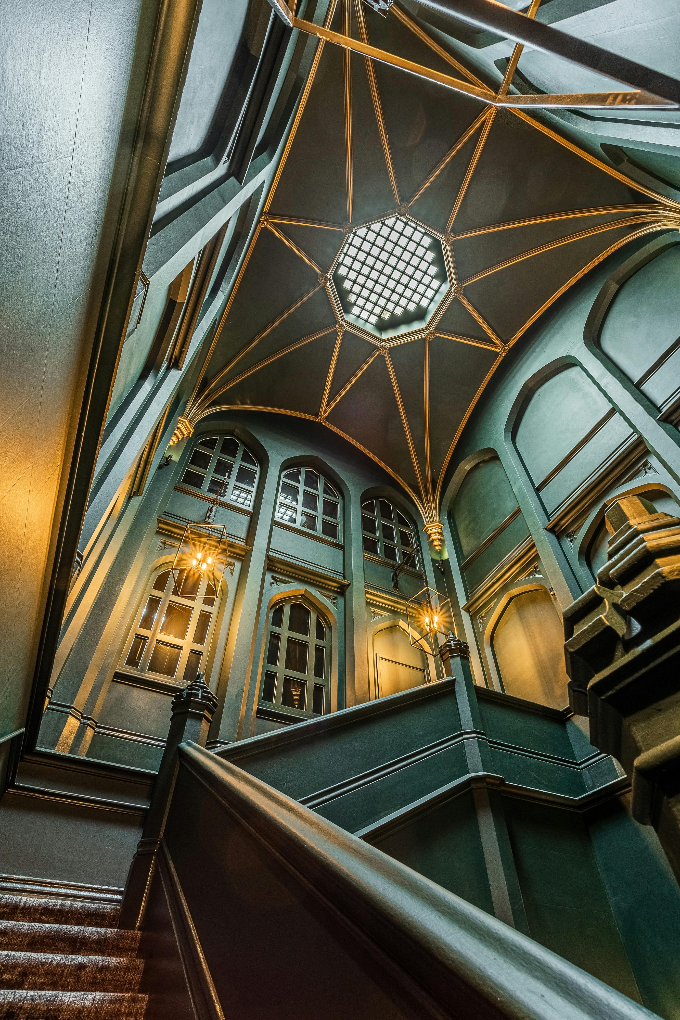 Caption: a staircase in a building with a decorative ceiling