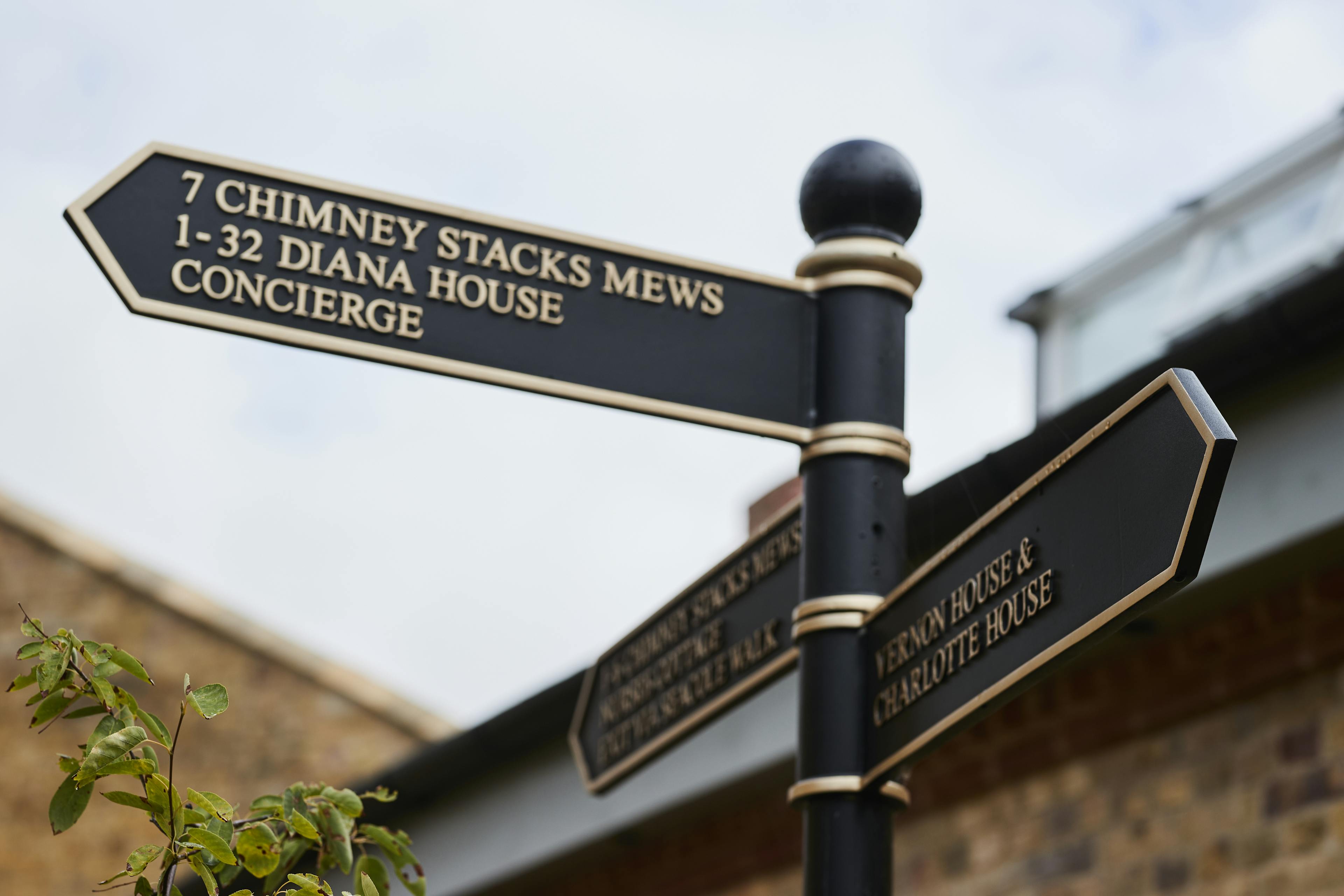 Caption: a street sign in front of a brick building