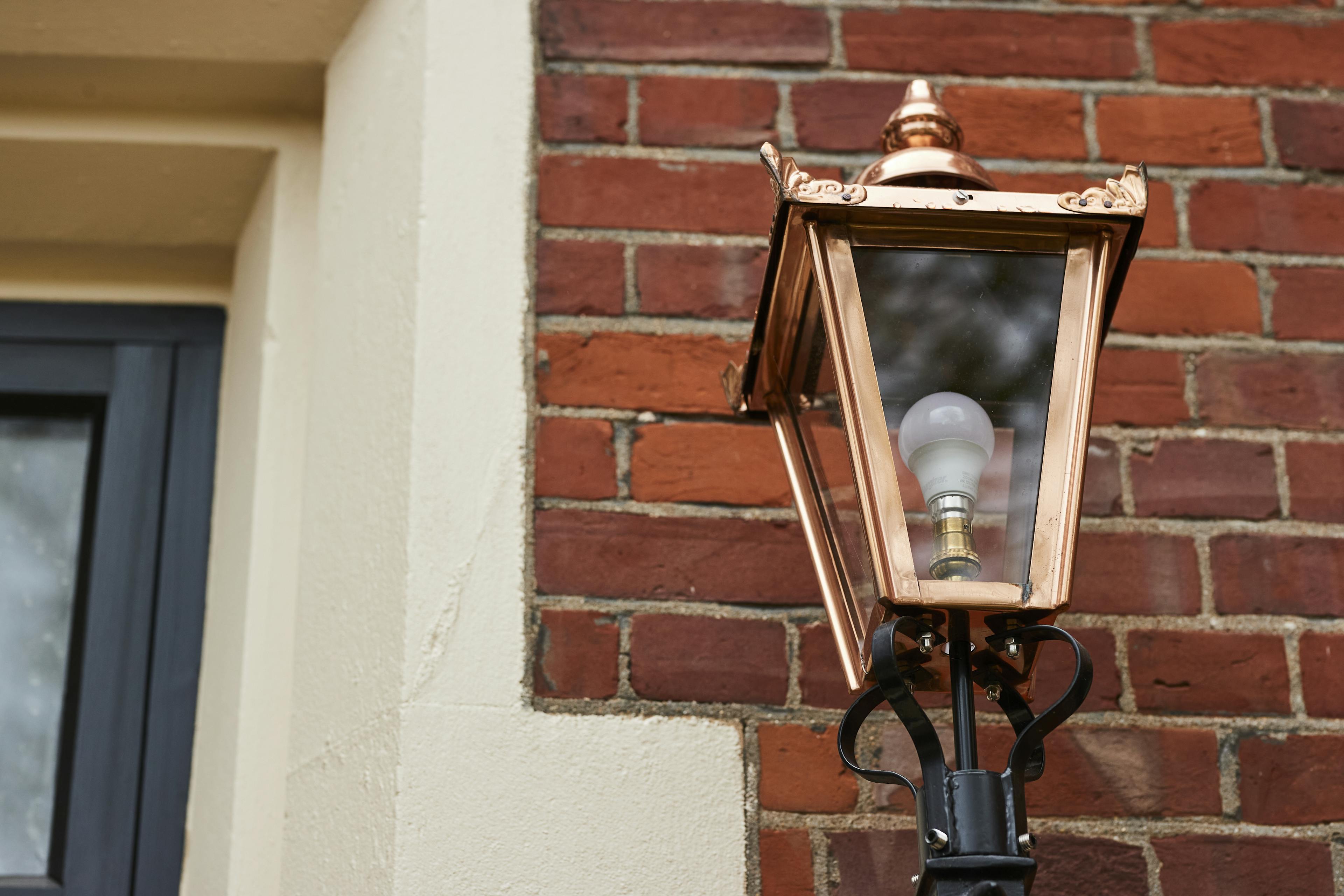 Caption: a street light with a brick wall in the background
