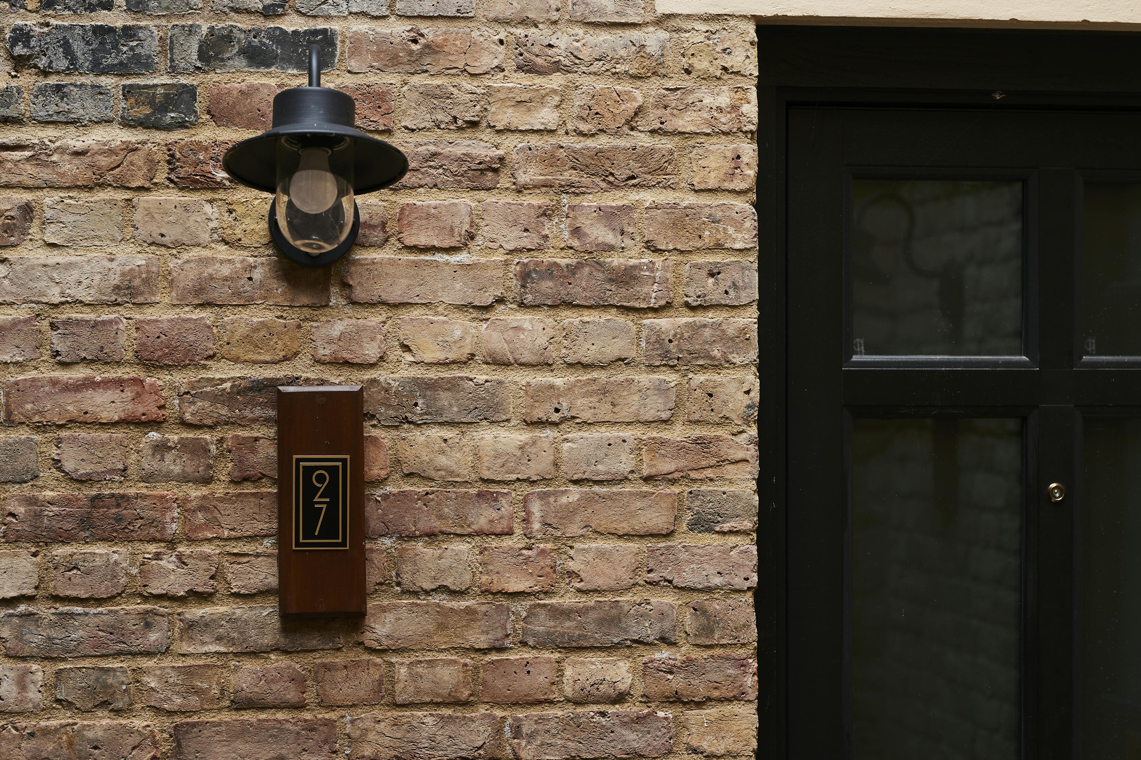 Caption: a clock mounted to the side of a brick building