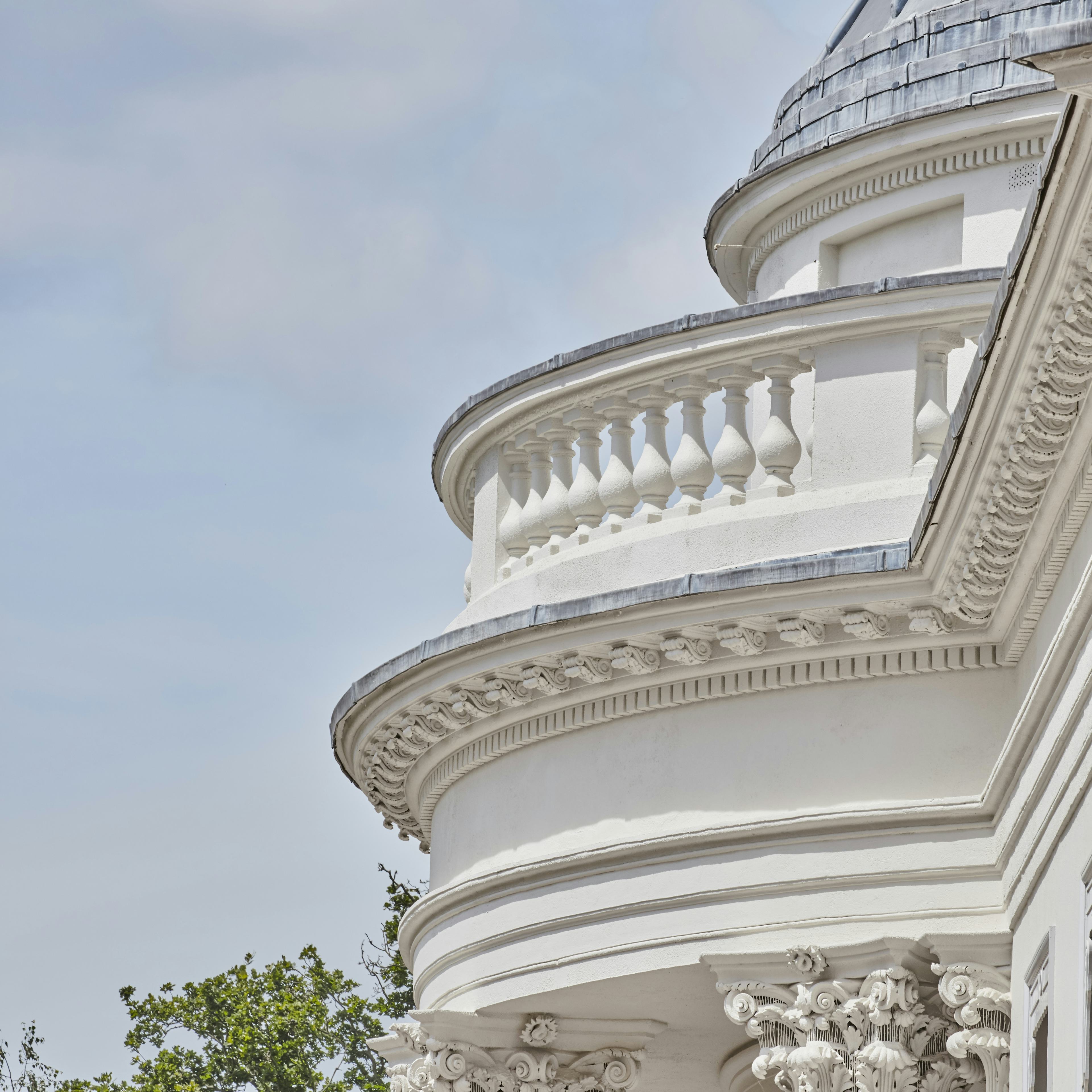 Caption: a white building with a clock on the front of it