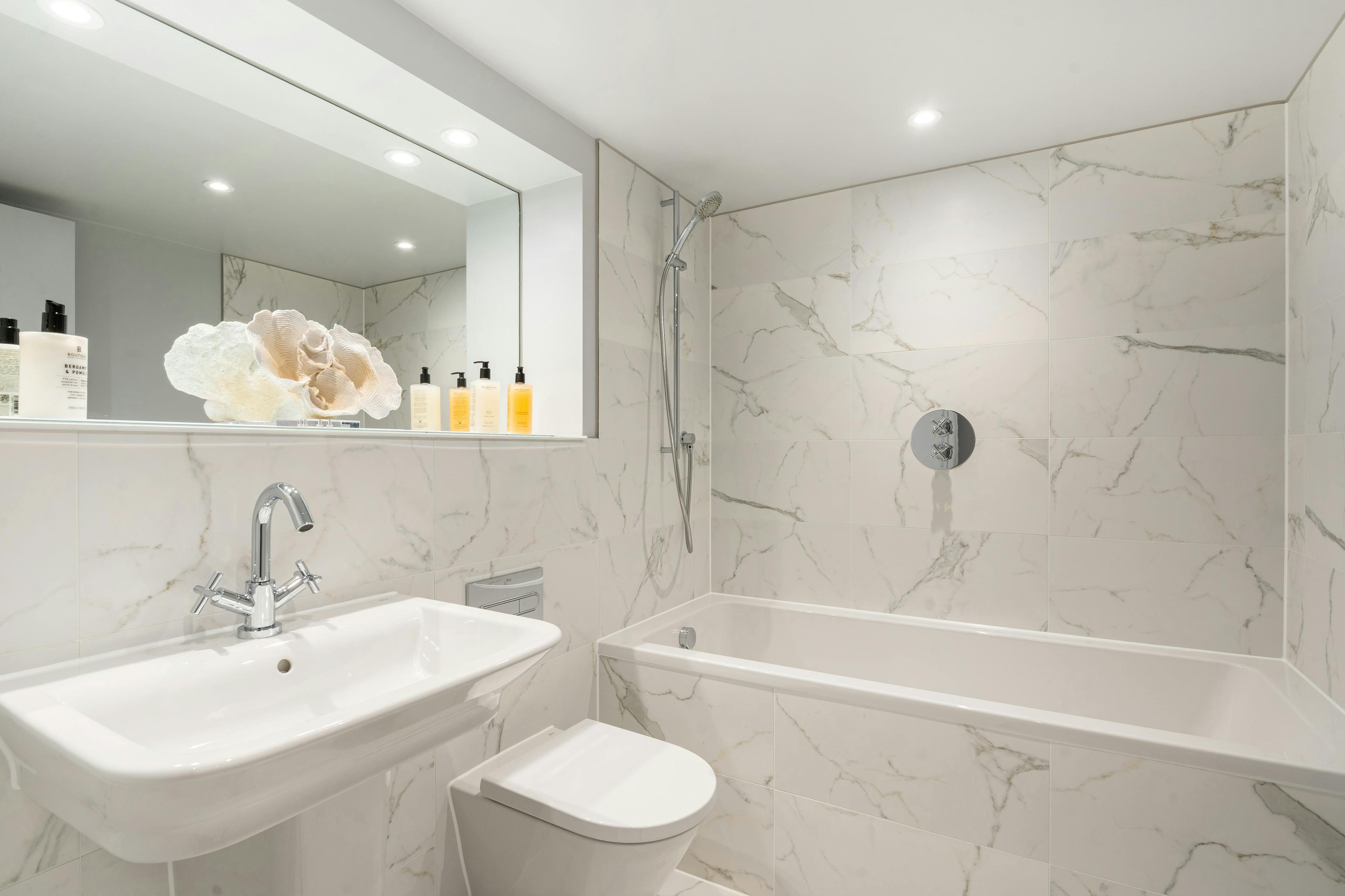 Caption: a bathroom with a toilet, sink, and bathtub