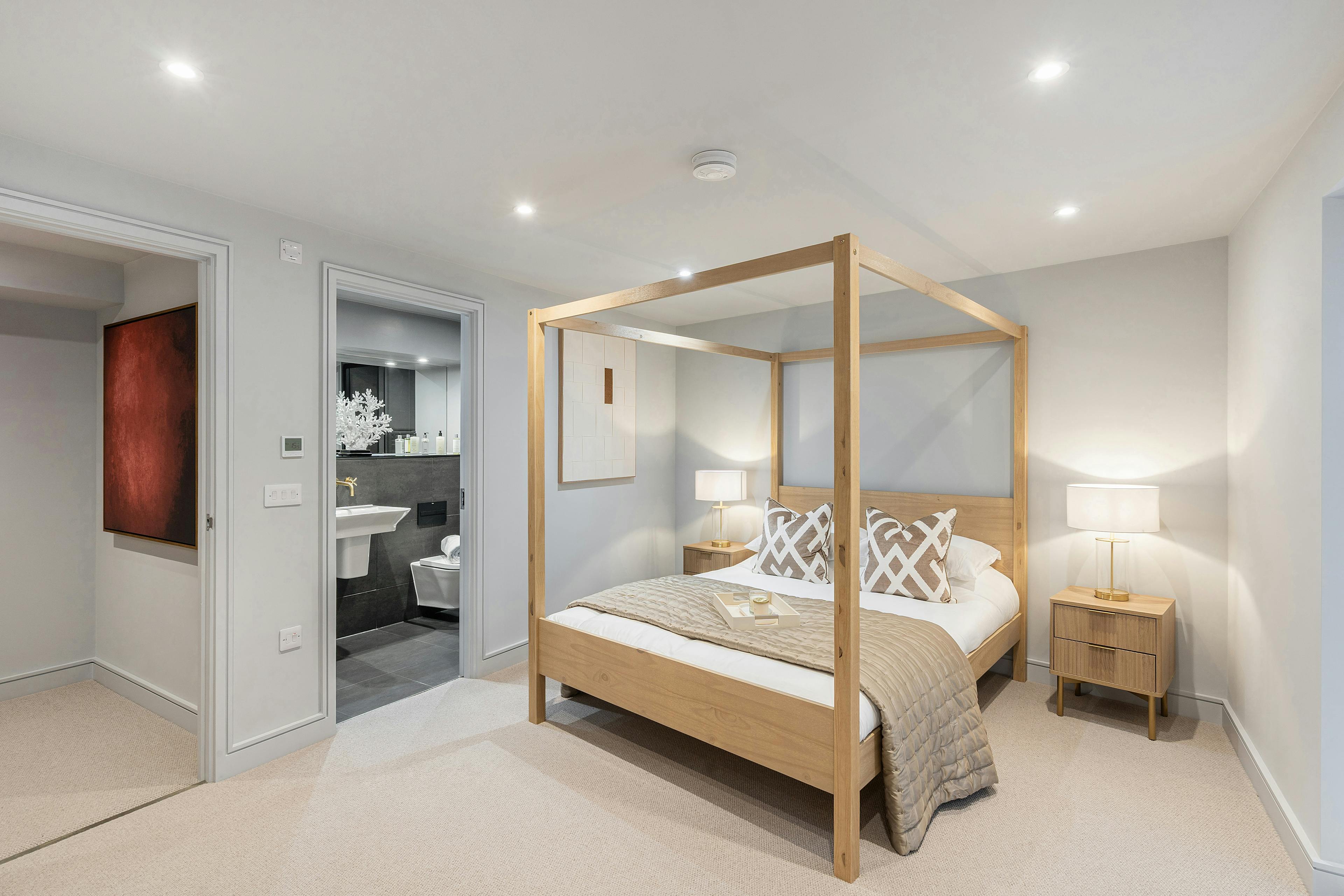 Caption: a bedroom with a four poster bed and a bathroom in the background