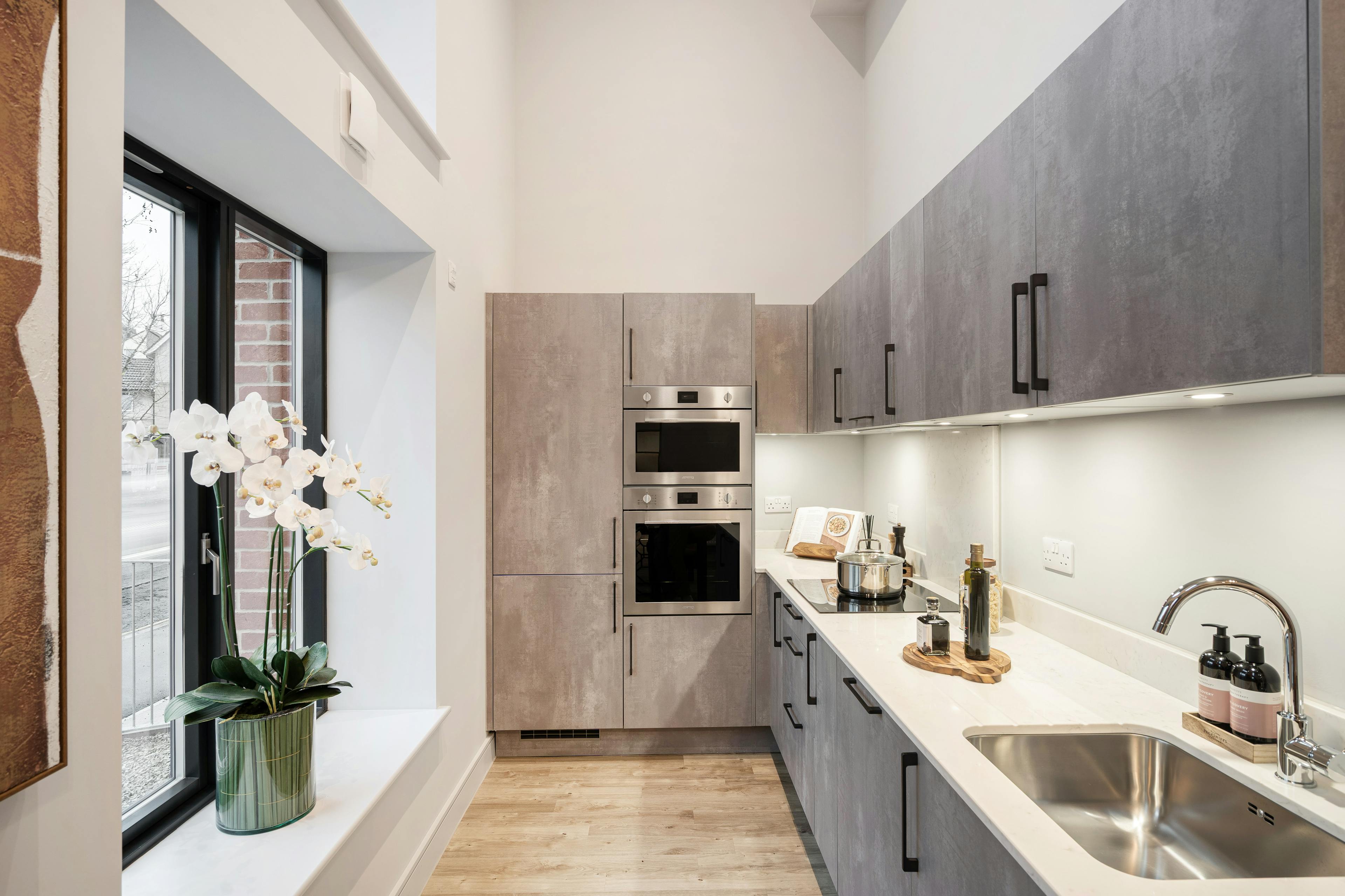 Caption: a kitchen with a sink, stove and a window