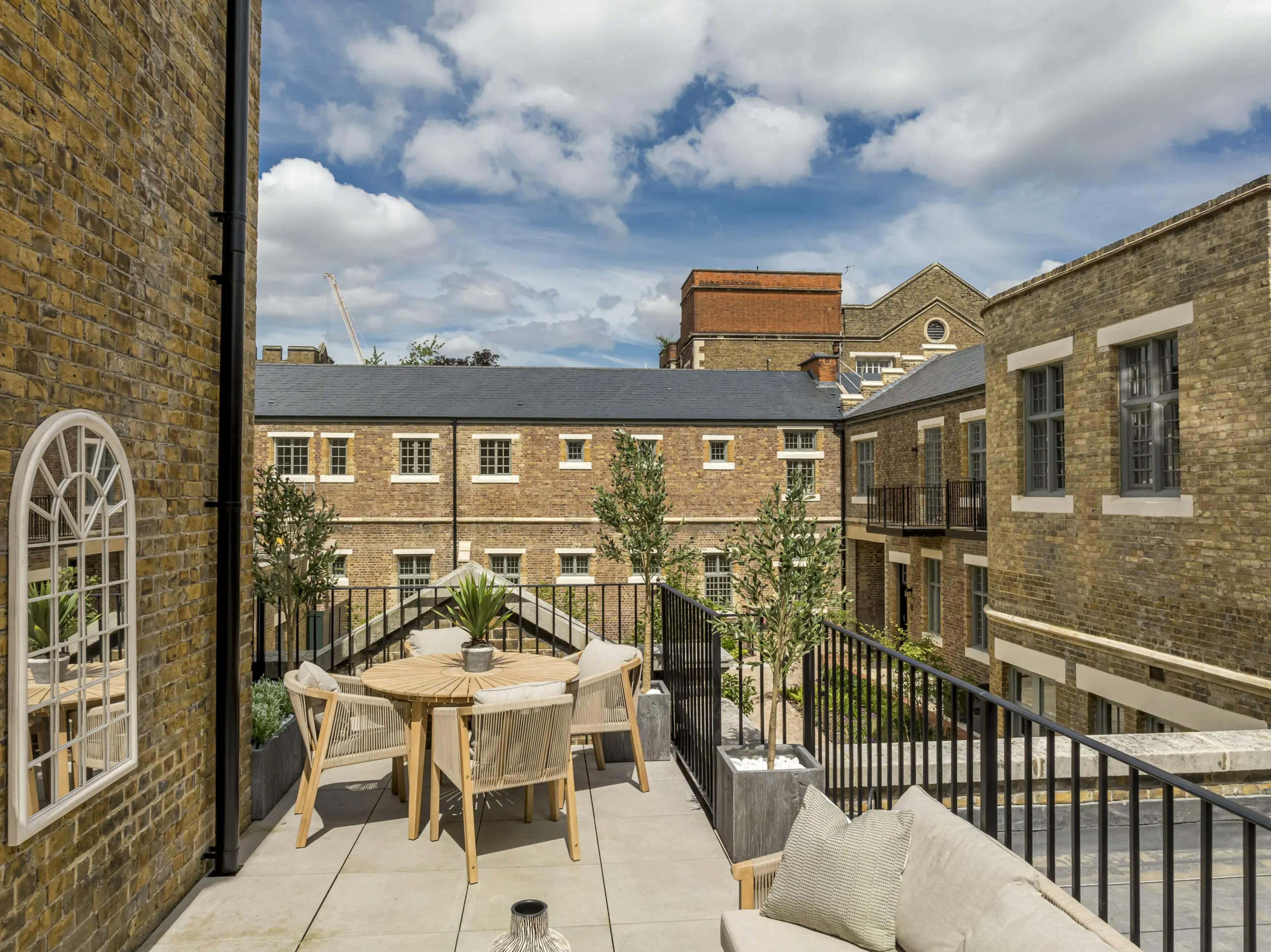 Caption: a balcony with a table and chairs on it