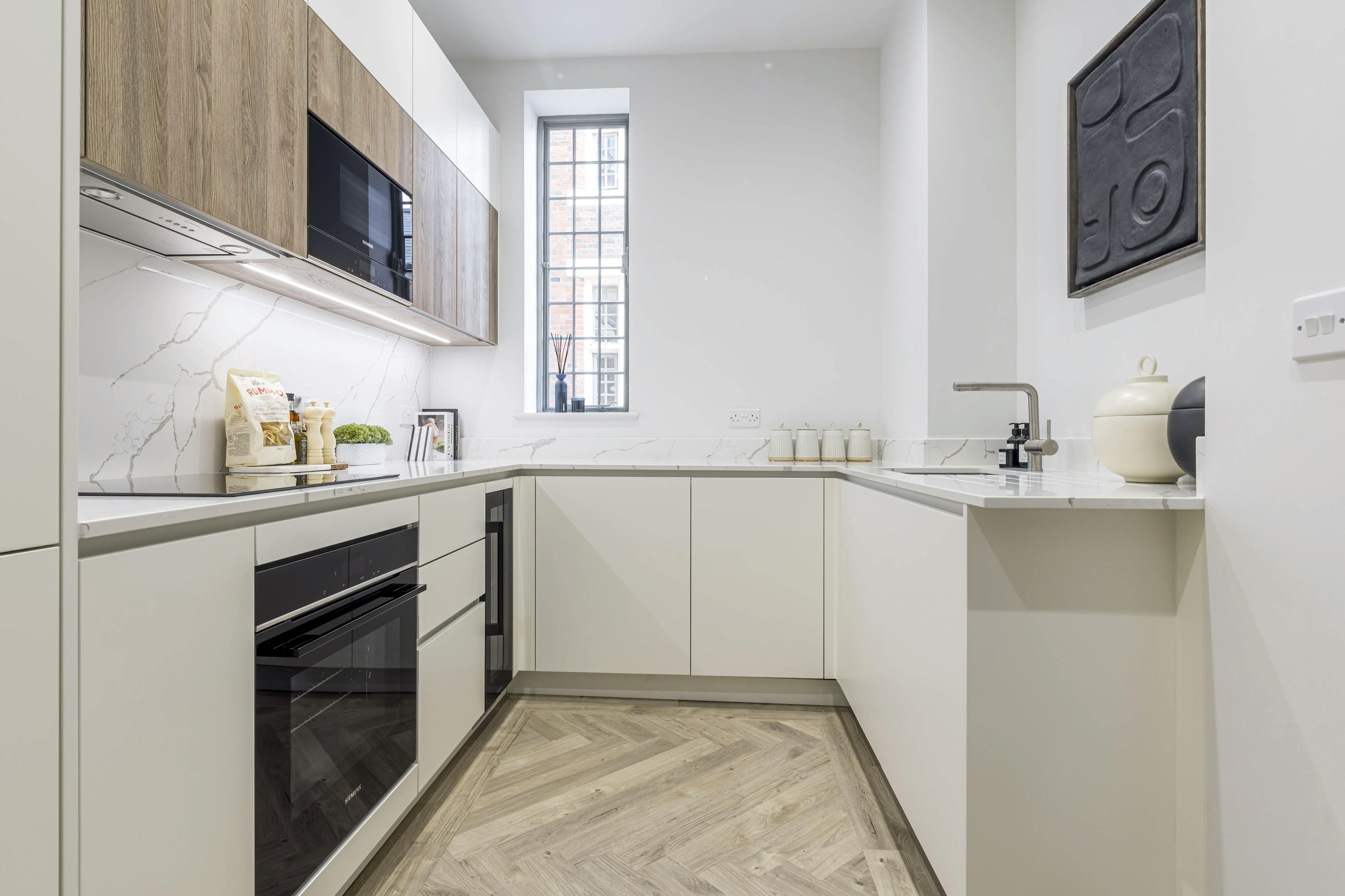 Caption: a kitchen with white cabinets and wood floors
