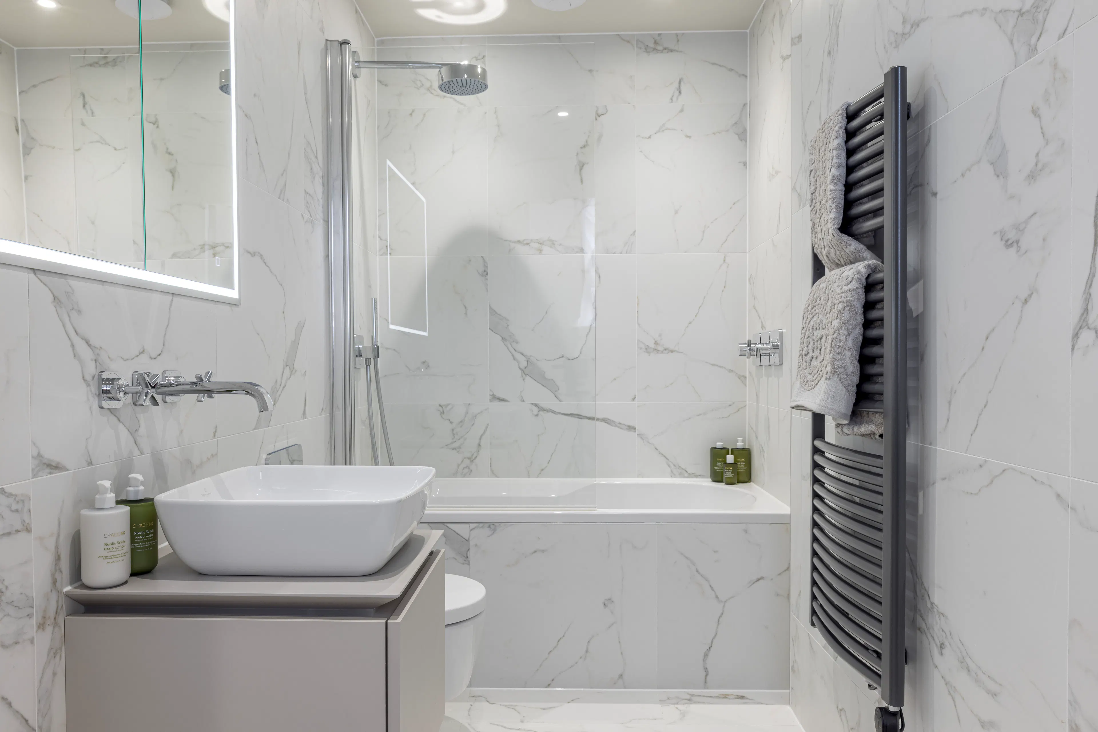 Caption: a bathroom with a sink, mirror and bathtub
