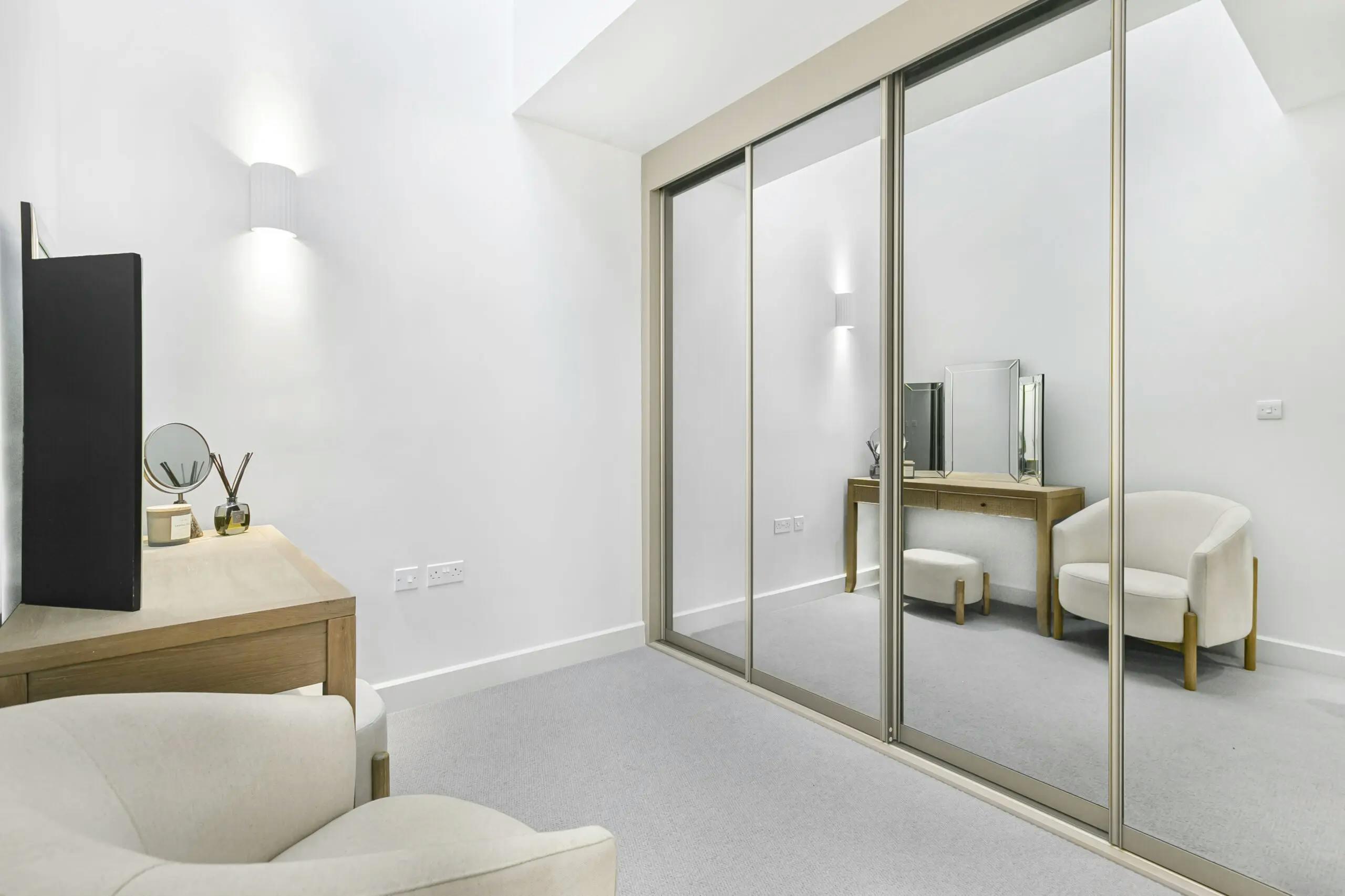 Caption: a room with a couch, mirror and a chair