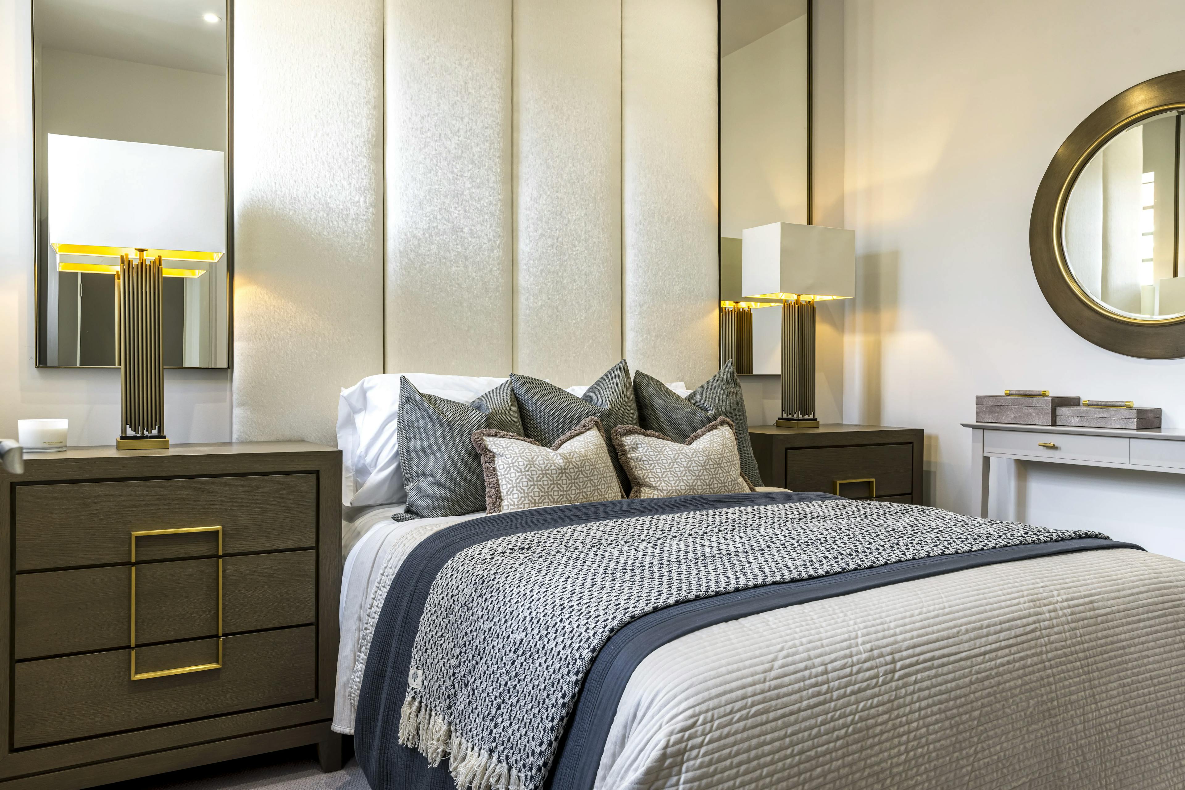 Caption: a bedroom with a bed, dresser and mirror