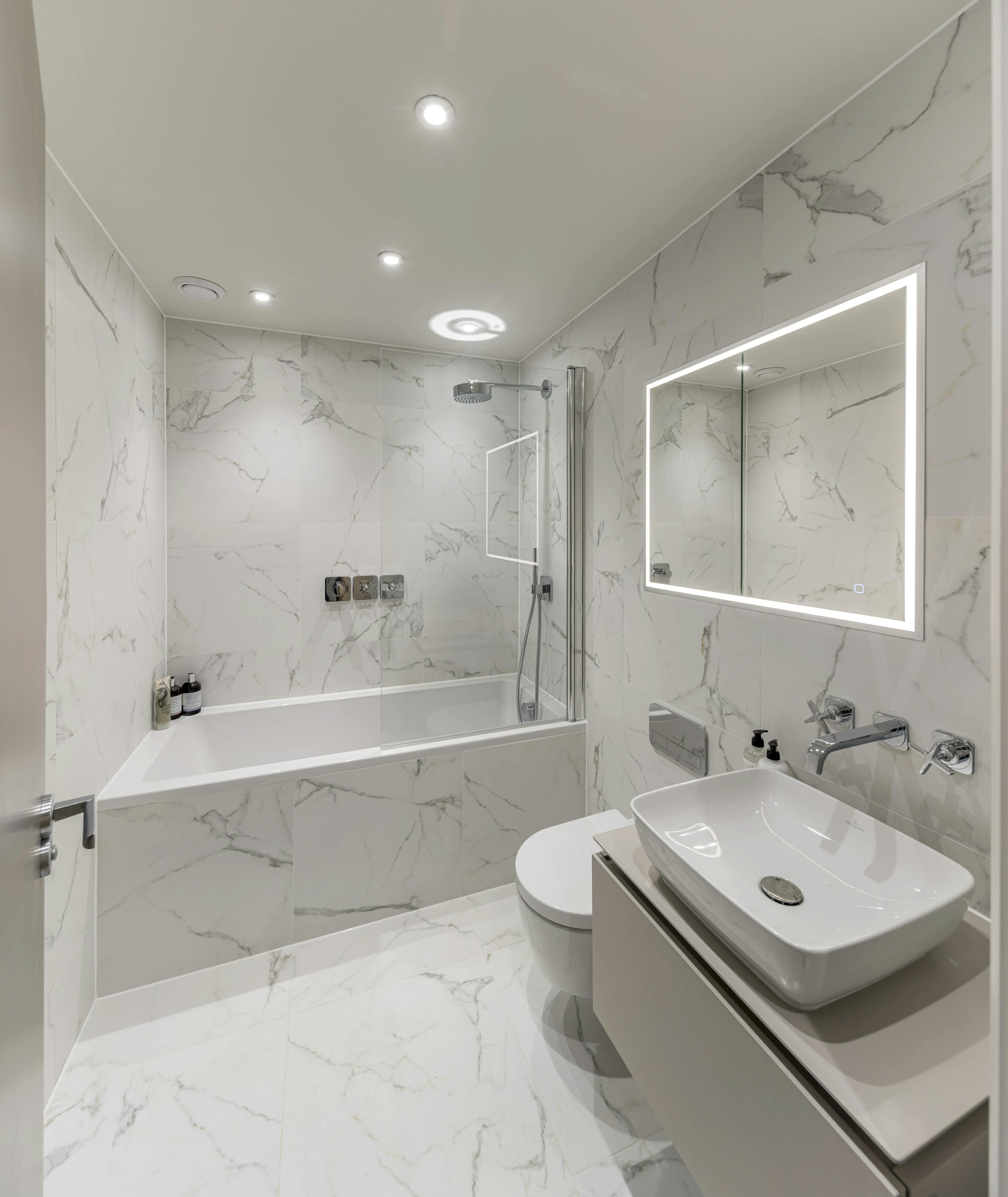 Caption: a bathroom with a sink, mirror, toilet and bathtub