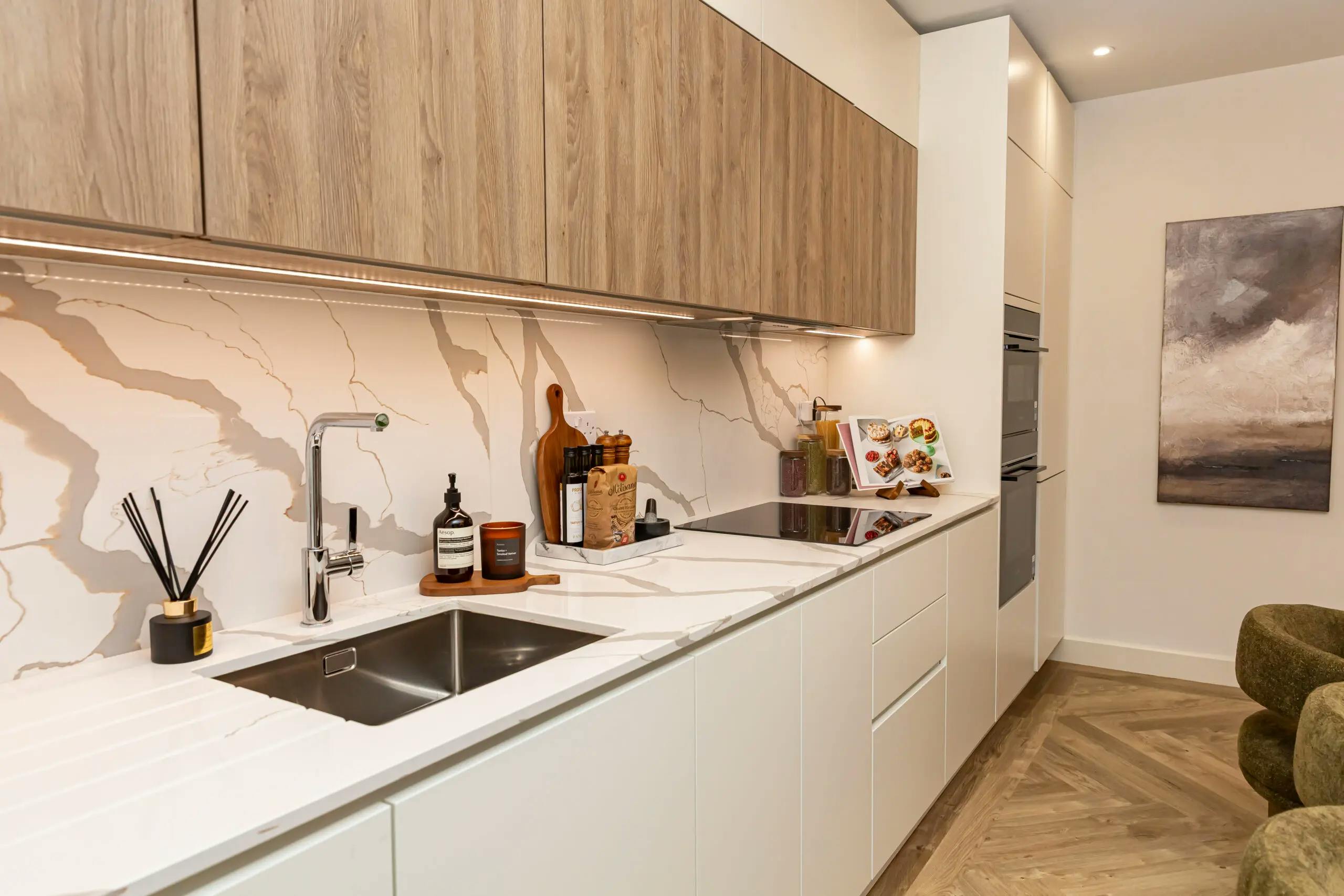 Caption: a kitchen with a sink and a painting on the wall