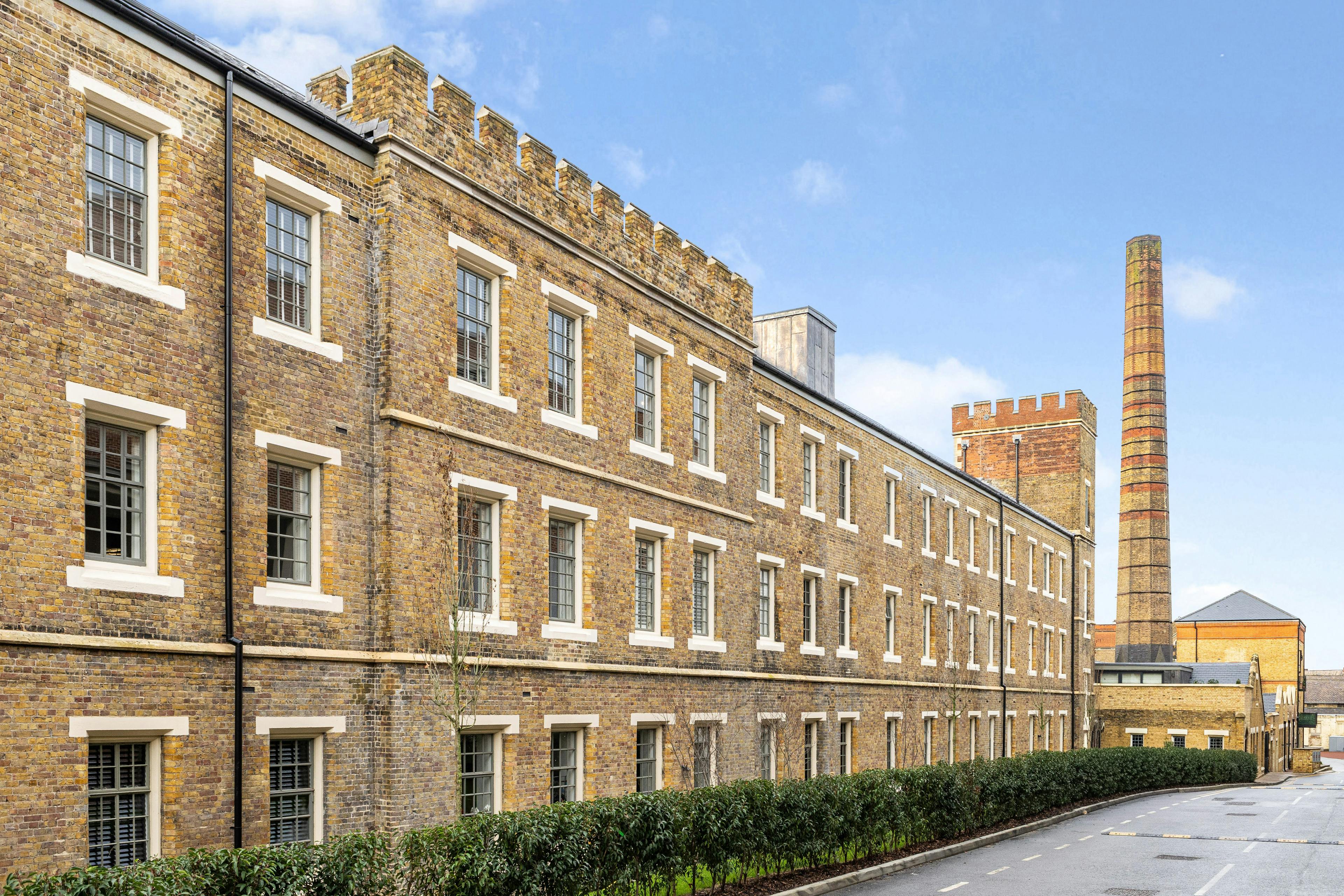 Caption: a large brick building with many windows and a clock tower in the background